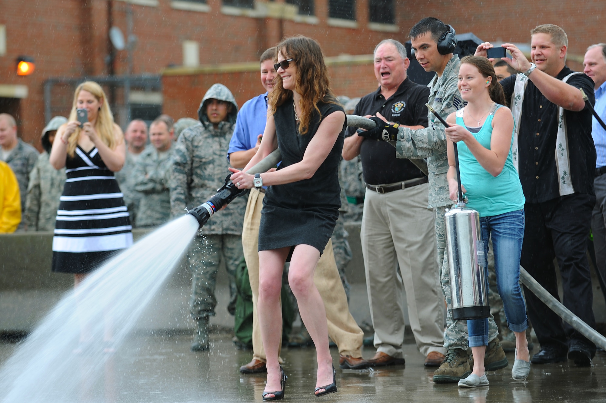 Family members and friends wait to greet U.S. Air Force Col. Kevin J. Robbins, 1st Fighter Wing commander, with water hoses and champagne bottles in celebration of his “fini flight” at Langley Air Force Base, Va., July 12, 2013. During Robbins’ career, he was responsible for the worldwide rapid deployment and employment of F-22 Raptor air dominance fighters. (U.S. Air Force photo by Airman 1st Class Victoria H. Taylor/Released)