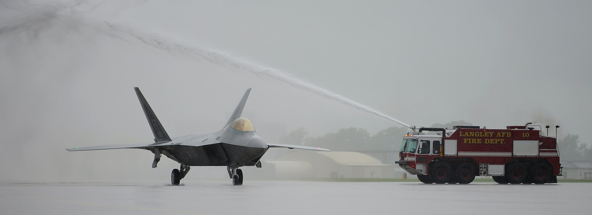 An F-22 Raptor piloted by U.S. Air Force  Col. Kevin J. Robbins, 1st Fighter Wing commander, passes beneath an arc of water after his “fini flight” at Langley Air Force Base, Va., July 12, 2013. Robbins has been a command pilot with more than 3,600 flight hours in the F-22, F-15, and the F-16. (U.S. Air Force photo by Airman 1st Class Victoria H. Taylor/Released)