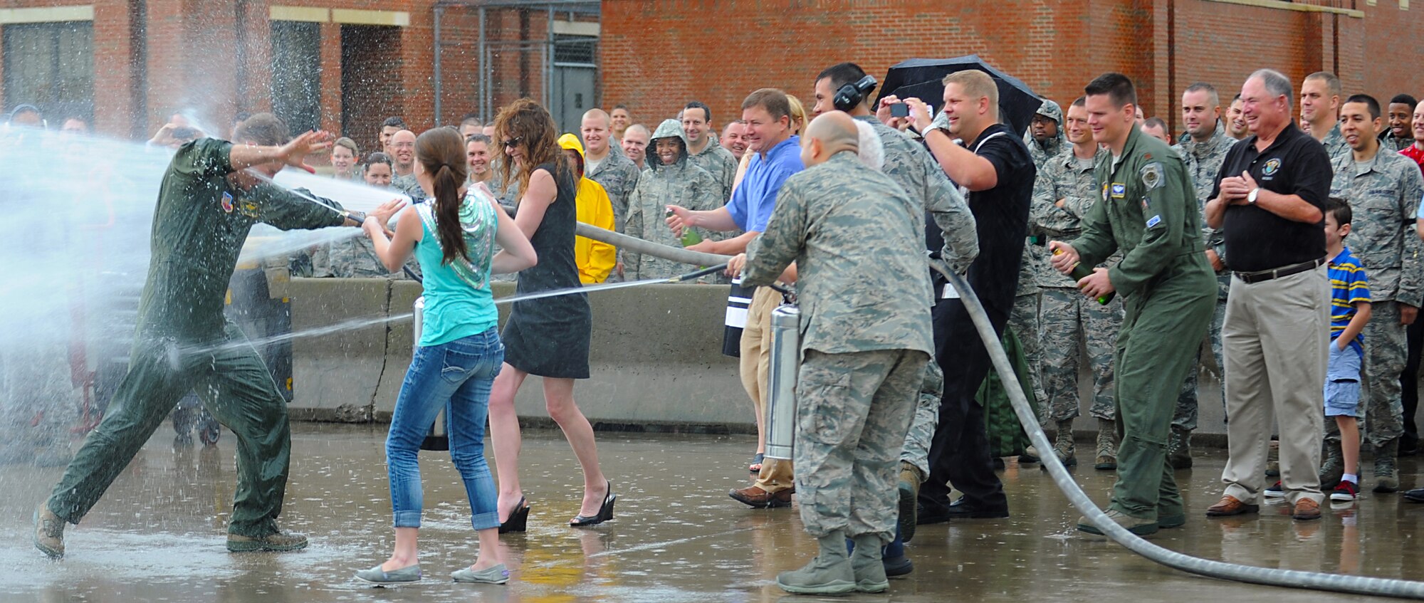 U.S. Air Force Col. Kevin J. Robbins, 1st Fighter Wing commander, gets sprayed by friends and family after his “fini flight” at Langley Air Force Base, Va., July 12, 2013. The “fini flight” is the last flight before retirement and is an Air Force tradition which can be traced back to the Vietnam War. (U.S. Air Force photo by Airman 1st Class Victoria H. Taylor/Released)