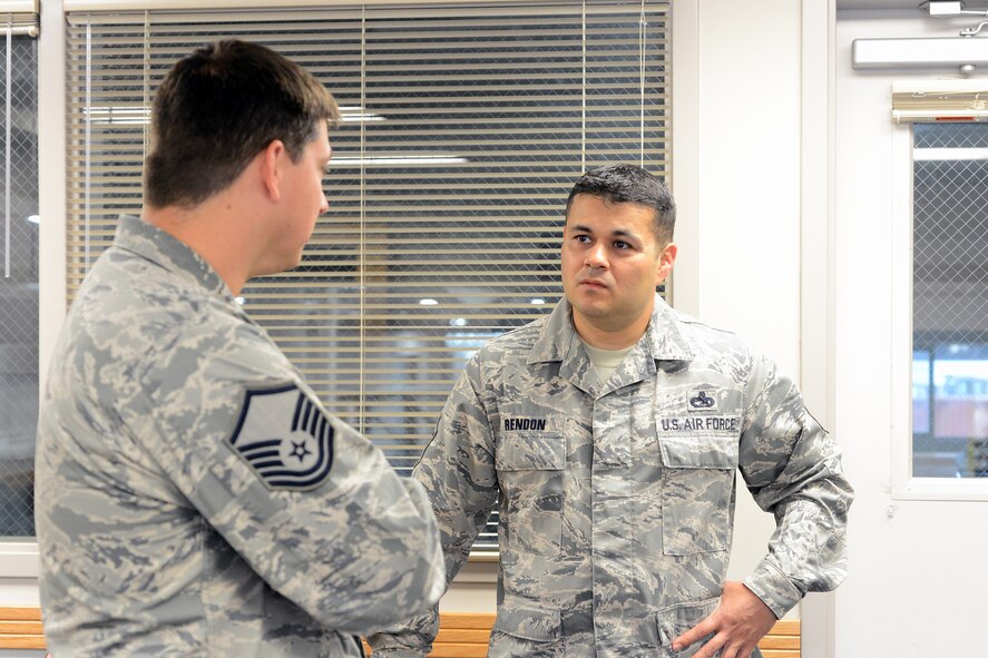 Senior Master Sgt. Ernesto Rendon, 62nd Aerial Port Squadron air freight superintendent, listens to Master Sgt. David Merchlewitz, 62nd APS air terminal operations center NCO in charge, work performance assessment of Airmen in the squadron. Rendon will soon go to the Air Force Enlisted Council as one of the 12 Outstanding Airmen, where he will serve one year. (U.S. Air Force photo/Airman 1st Class Jacob Jimenez)