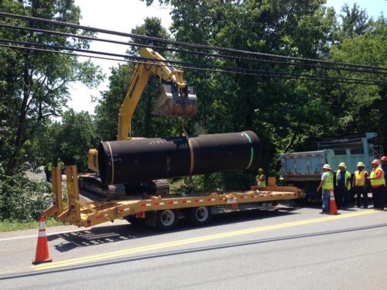 Washington Suburban Sanitary Commission employees move a ductile replacement pipe  to replace the currently failing 54" pipe, July 16, 2013, in Prince George's County, Md. Joint Base Andrews begins "mission critical personnel only" operations at 9 p.m. on July 16. (WSSC photo) 