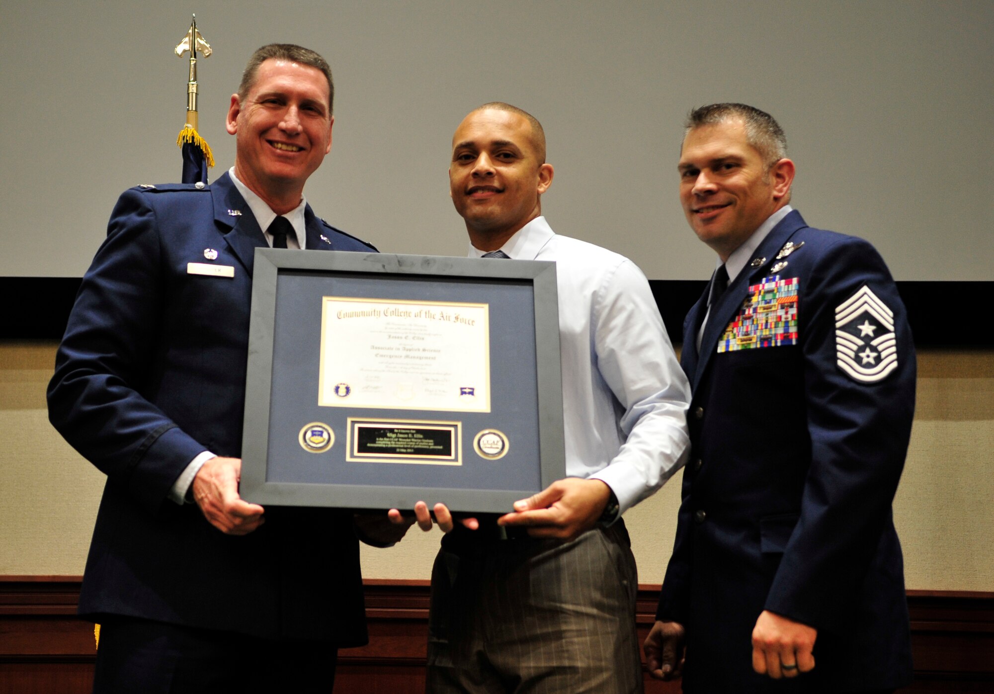 Retired Staff Sgt. Jason Ellis, former command post technician, receives his Community College of the Air Force associate’s degree from Col. Barry Roeper, 6th Maintenance Group commander, and Chief Master Sgt. Thomas Mazzone, 6th Air Mobility Wing command chief, May 23, 2013 at MacDill Air Force Base, Fla. Ellis is the first wounded warrior to receive his degree through the new CCAF Wounded Warrior Program, which allows members to finish their degrees once they have separated from the Air Force. (U.S. Air Force photo by Airman 1st Class Sarah Breer/Released)