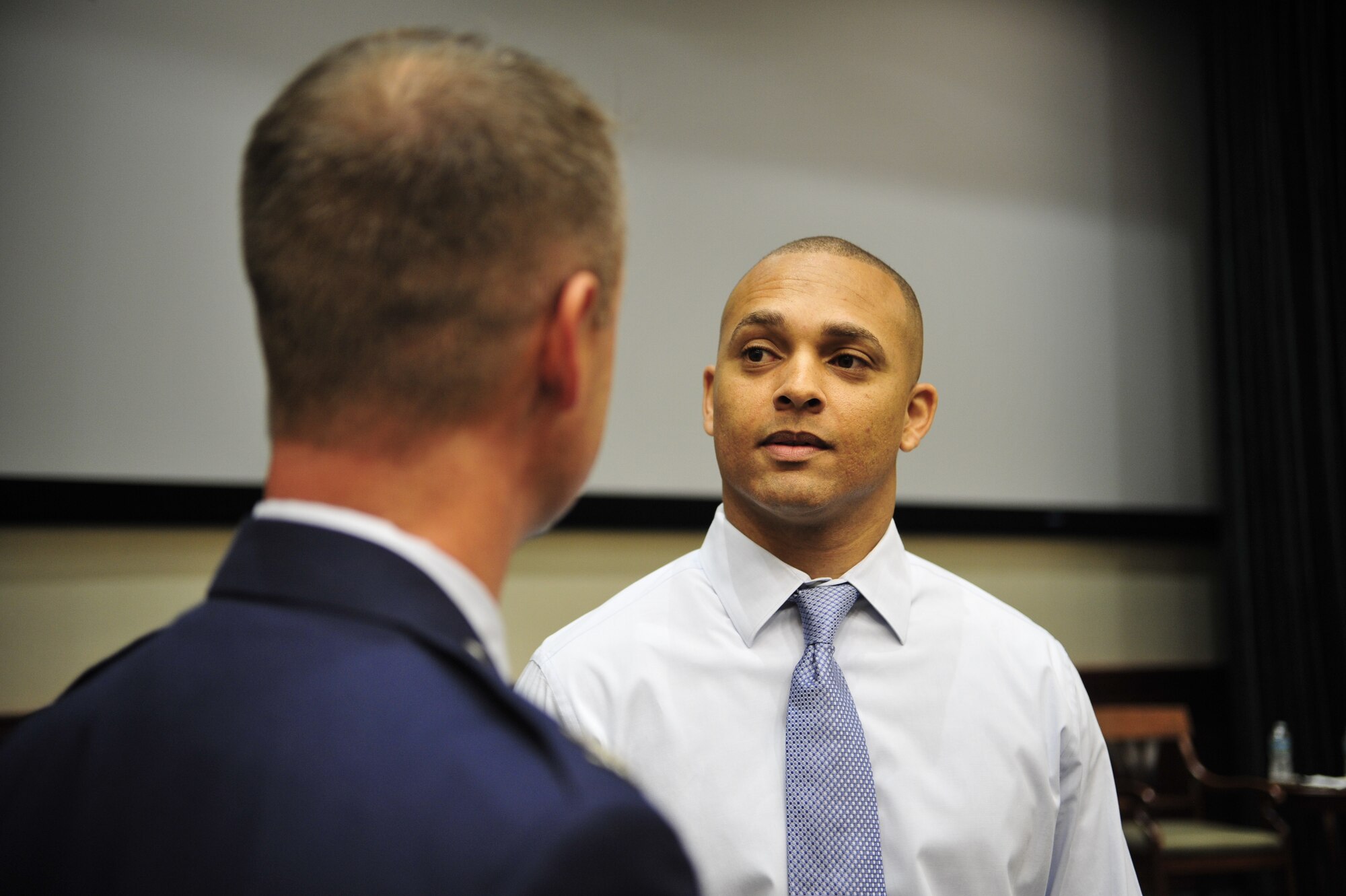 Retired Staff Sgt. Jason Ellis, former command post technician, speaks with Col. James Hodges, 6th Mission Support Group commander, after receiving his Community College of the Air Force associate’s degree at MacDill Air Force Base, Fla. May 23, 2013. The Wounded Warrior Program was started by the CCAF so that members who were separated from the service could complete their degree. (U.S. Air Force photo by Airman 1st Class Sarah Breer/Released)