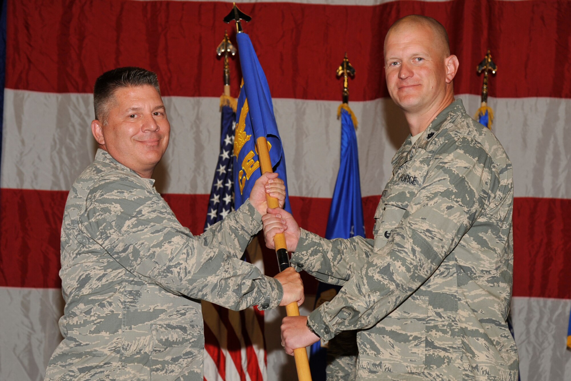 PETERSON AIR FORCE BASE, Colo. – The 21st Civil Engineer Squadron held its change of command ceremony July 9 at the Peterson fire station. Col. Charles Arnold (left) 21st Mission Support Group commander, passes the 21st CES guidon to Lt. Col. Joshua DeMotts, incoming commander. DeMotts replaces the outgoing commander Lt. Col. Mark Donnithorne. (U.S. Air Force photo/Robb Lingley)