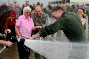 U.S. Air Force Col. Kevin J. Robbins, 1st Fighter Wing commander, is hosed down by his wife and family as he completes his “fini flight” at Langley Air Force Base, Va., July 12, 2013. Immediately following his “fini flight,” Robbins retired as commander of the 1st FW. (U.S. Air Force photo by Senior Airman Kayla Newman/Released)
