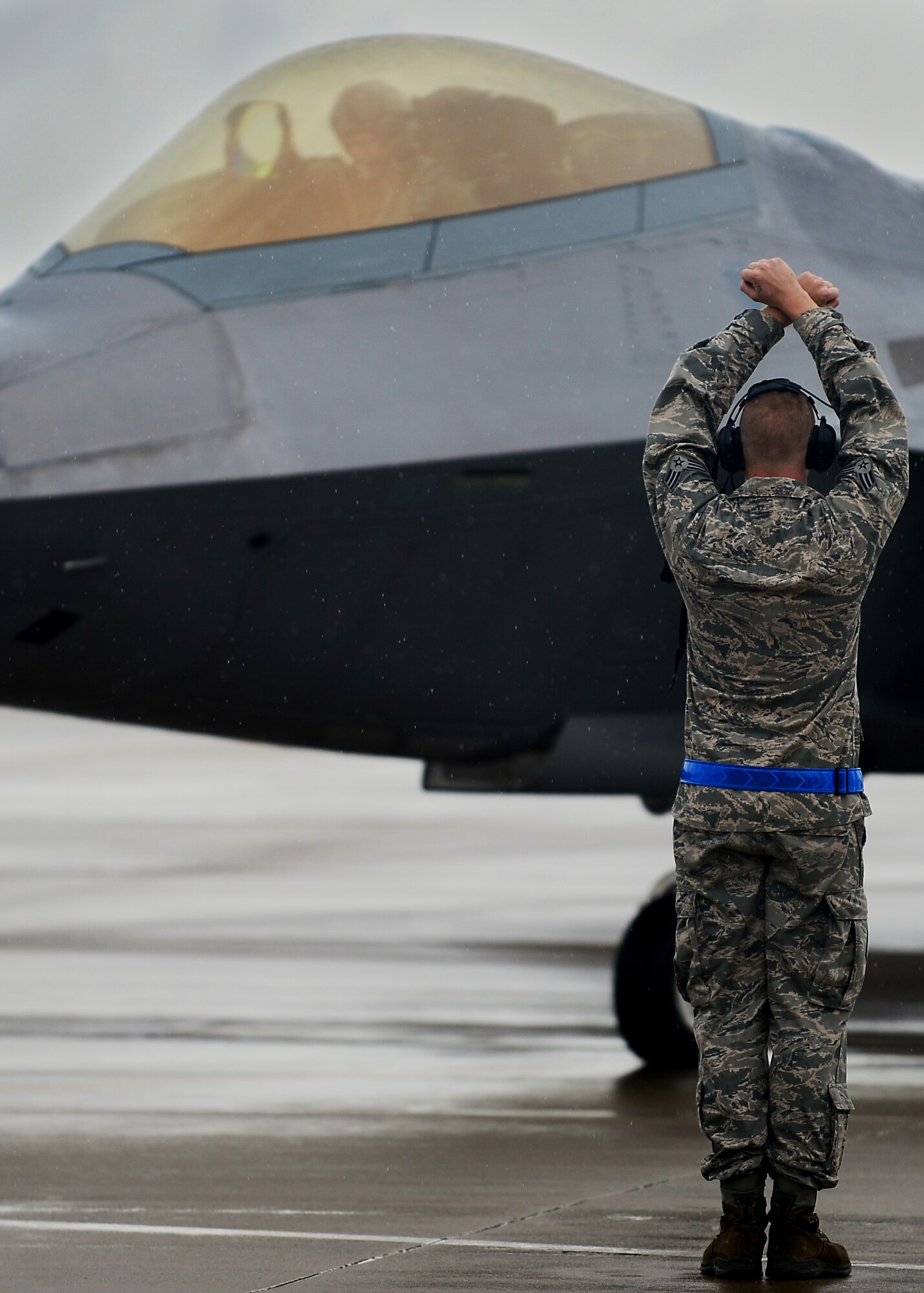 U.S. Air Force Senior Airman Jaymes Baum, 1st Maintenance Squadron F-22 Raptor crew chief, signals to Col. Kevin J. Robbins, 1st Fighter Wing commander, during the colonel’s “fini flight” at Langley Air Force Base, Va., July 12, 2013. As commander, Robbins oversaw 1,400 personnel, two airfields, two groups and six squadrons, including two F-22 Raptor fighter squadrons and a T-38 Talon Adversary Air detachment. (U.S. Air Force photo by Senior Airman Kayla Newman/Released)