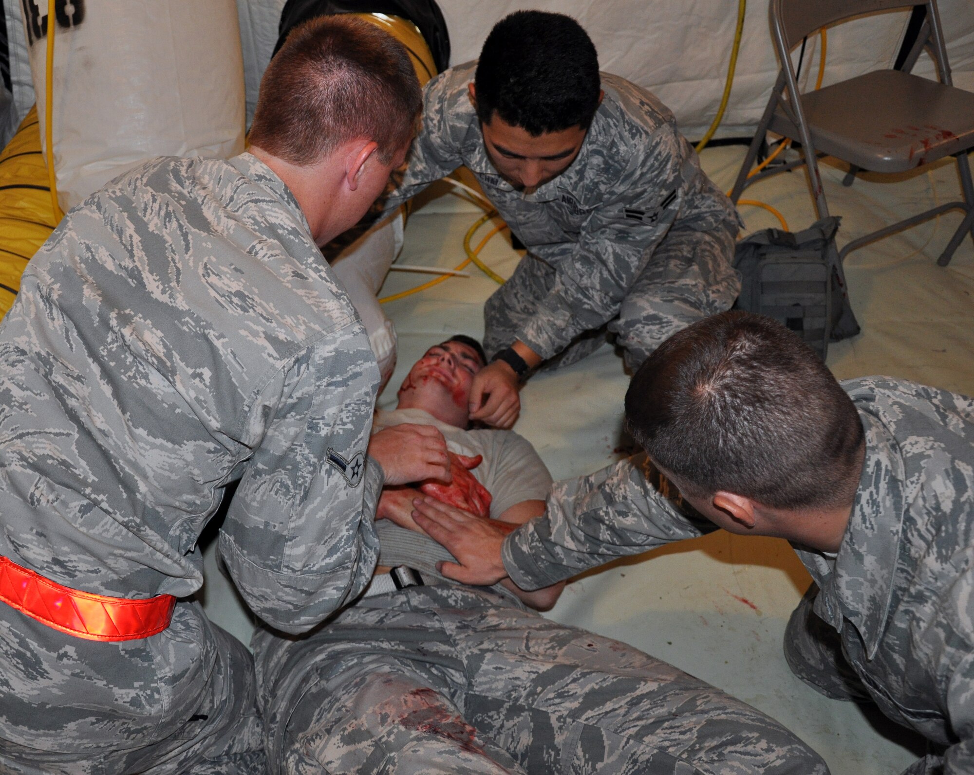 Members of Team McConnell practice self-aid buddy care on a mock victim during an Operational Readiness Excercise at McConnell Air Force Base, Kan., July 16, 2013.  The exercise was designed to test and train members of Team McConnell on wartime readiness skills.  (U.S. Air Force photo by Capt. Zach Anderson)
