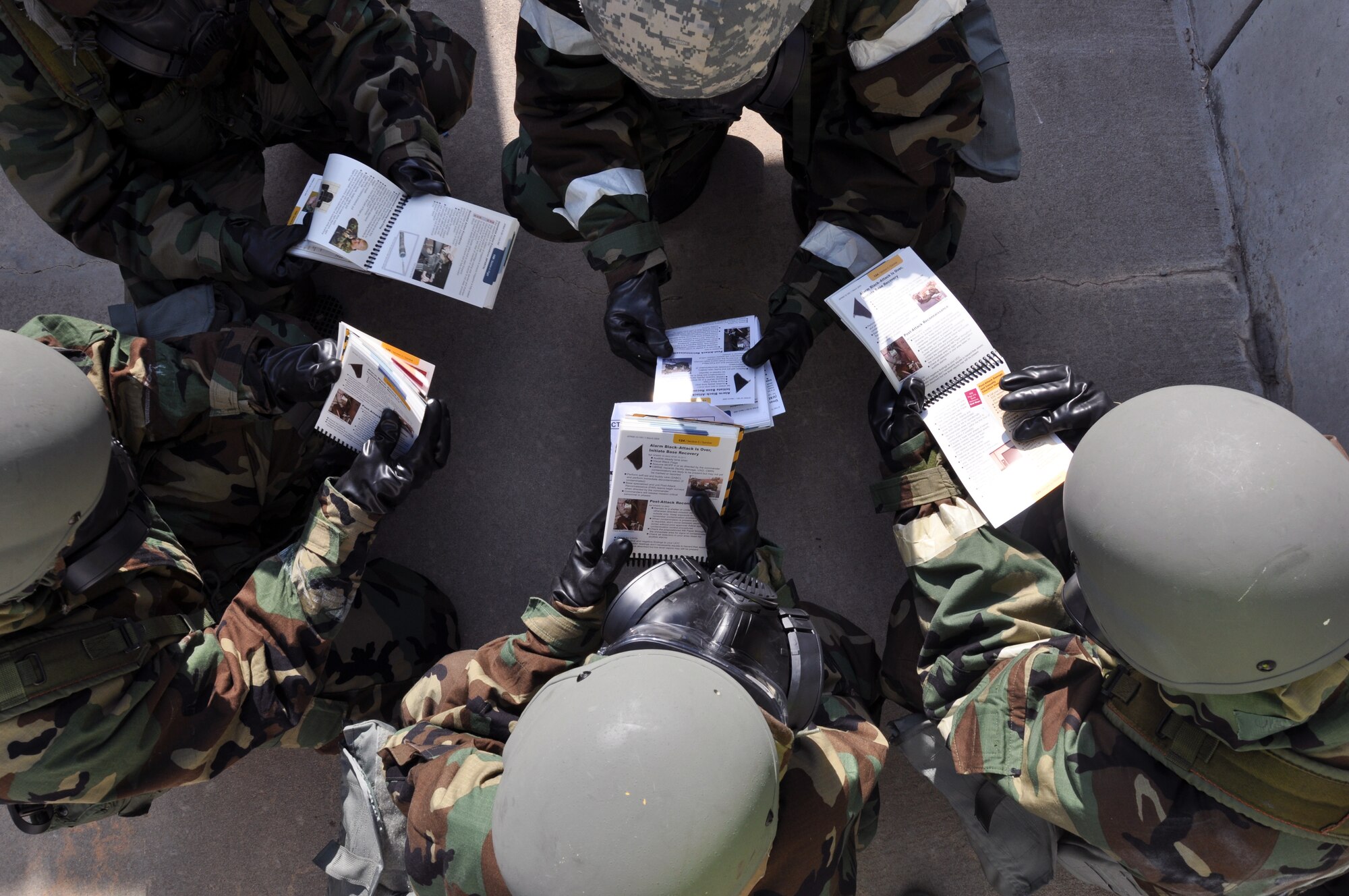 Members of Team McConnell review their Airman's Manuals while conducting ability to survive and operate (ATSO) training during an Operational Readiness Excercise at McConnell Air Force Base, Kan., July 16, 2013.  The exercise was designed to test and train members of Team McConnell on wartime readiness skills.  (U.S. Air Force photo by Capt. Zach Anderson)