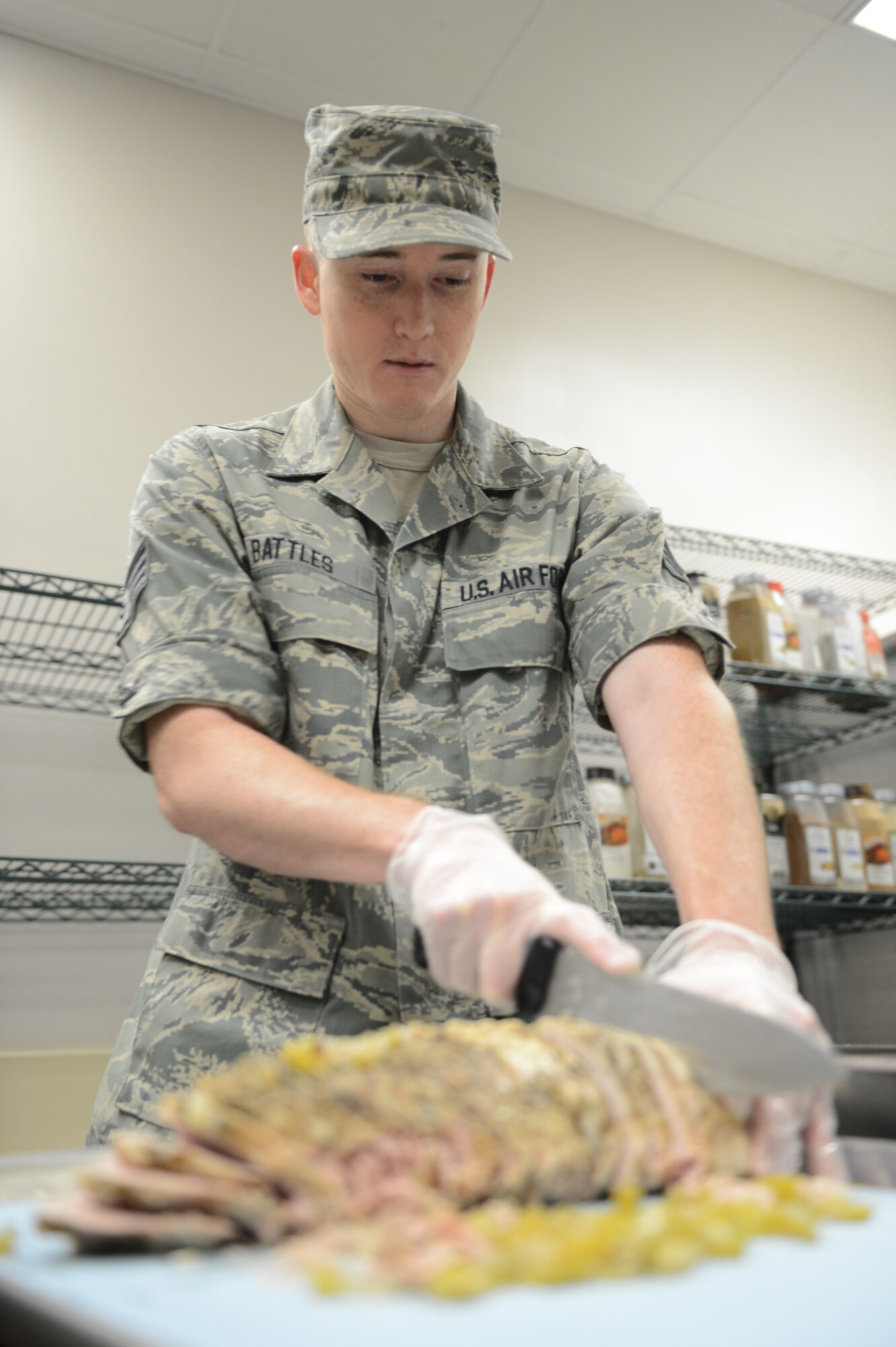 Staff Sgt. Matthew Battles, 20th Force Support Squadron shift supervisor, slices pork tenderloin for lunch at the Chief Master Sgt. Emerson Williams Dining Facility at Shaw Air Force Base, July 11, 2013. The dining facility staff prepares breakfast, lunch, dinner and midnight meals each day for service members. (U.S. Air Force photos by Airman 1st Class Krystal M. Jeffers/Released)