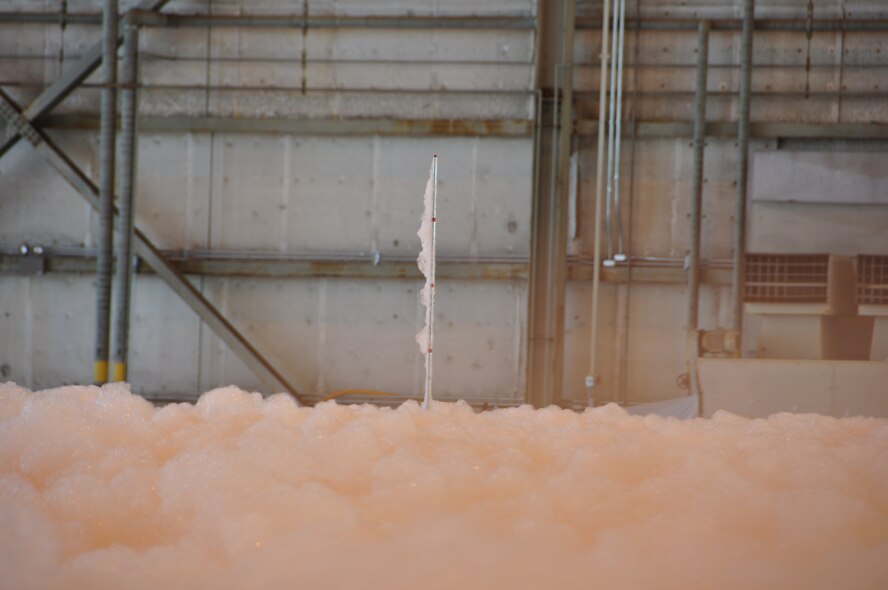 Fire-suppressant foam hits the floor of hangar 818 while they tested the new system July 10, 2013, in Hangar 818 at Travis Air Force Base, Calif. It took less than five minutes to fill the hangar with a 6-foot layer of foam. (U.S. Air Force photo/2nd Lt. Jessica Clark)
