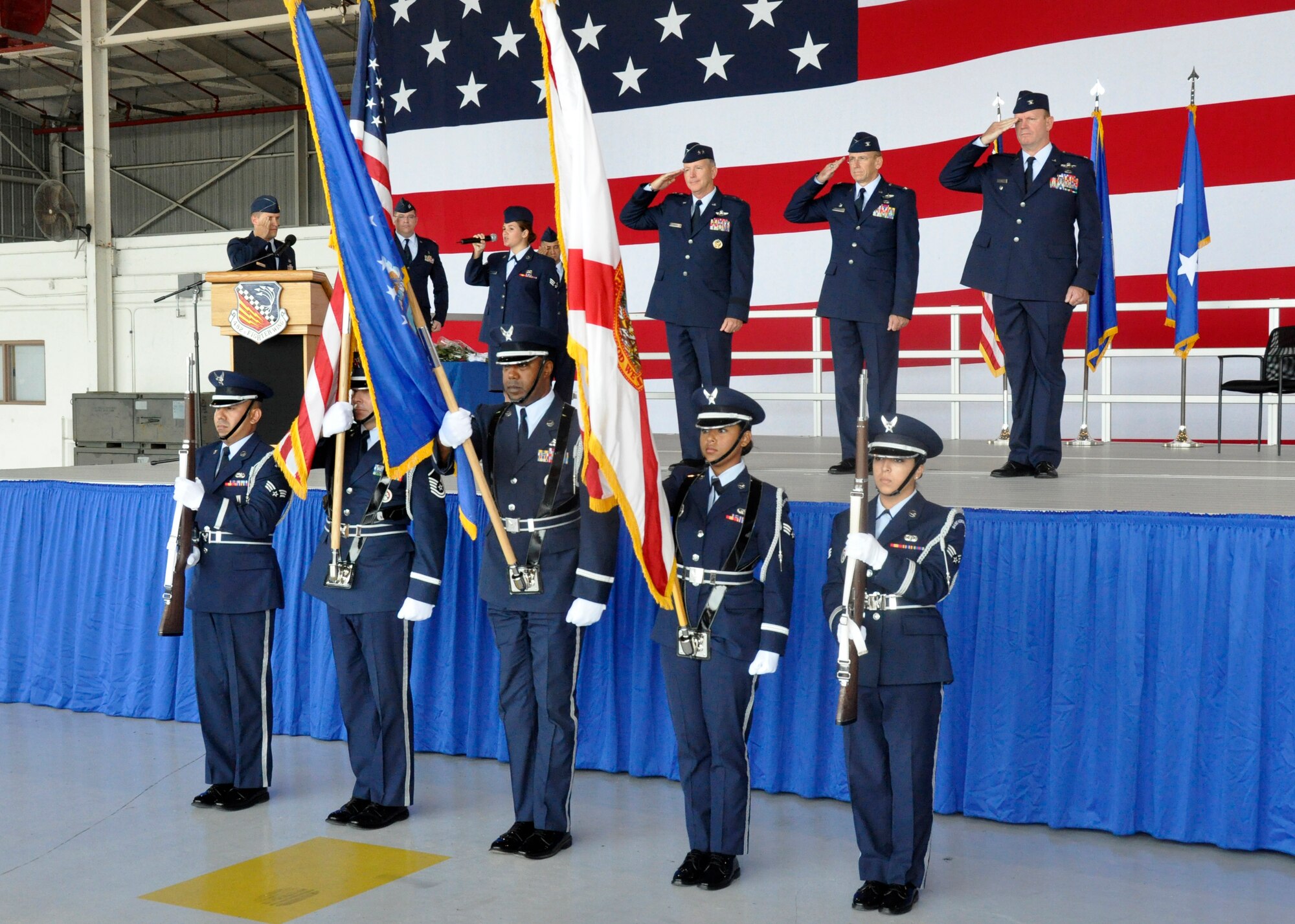 Maj. Gen. William B. Binger, 10th Air Force commander, Chief Master Sgt. Cameron Kirksey, Air Force Reserve Command command chief master sergeant, Col. Donald R. Lindberg, new 10th Air Force vice commander, and Col. Christian G. Funk, new 482nd Fighter Wing commander,  stand at attention as Senior Airman Jessica Herndon, 482nd Security Forces Squadron, sings the National Anthem with the Homestead Air Reserve Base Honor Guard presenting the colors during the 482nd FW change of command ceremony at Homestead Air Reserve Base, Fla., July 14. (U.S. Air Force photo/Senior Airman Nicholas Caceres)