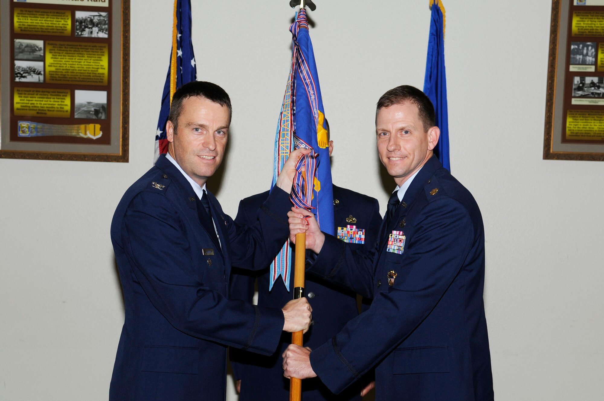 GOODFELLOW AIR FORCE BASE, Texas -- Col. Thomas Schmidt, 17th Training Wing Vice Commander, passes the 17th Comptroller Squadron guidon to the incoming commander, Maj. Brian Vance, during the Change of Command ceremony, July 11. The change of command ceremony is steeped in tradition and allows units to witness the formal command transfer from one officer to another.  (U.S. Air Force photo by Staff Sgt. Austin Knox)
