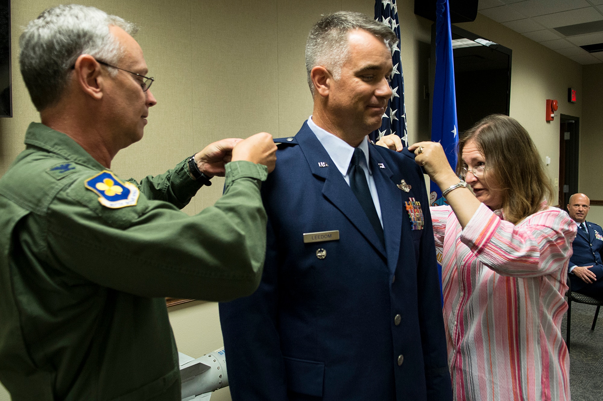 U.S. Air Force Col. Dave Leedom is "pinned" by his wife Linda and Col. Joseph Jones, 307th Bomb Wing vice commander, July 12, 2013, Barksdale Air Force Base, La. Leedom is the former commander of the 93rd Bomb Squadron and was recently promoted to the rank of Colonel. (U.S. Air Force photo by Master Sgt. Greg Steele/Released)