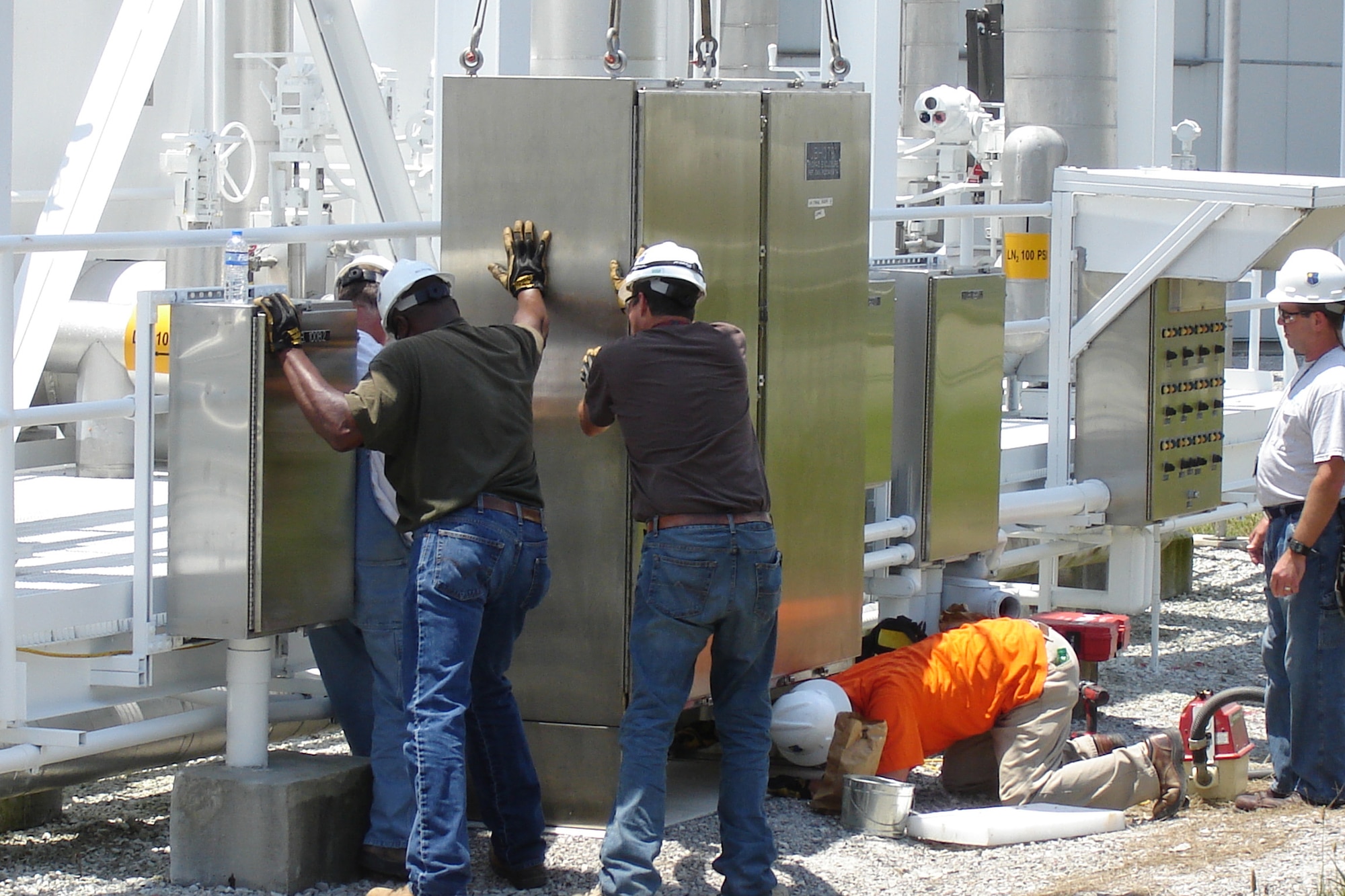 An AEDC systems installation crew positions the new remote Input/Output (I/O) control system cabinet for the complex’s Large Rocket Motor Test Facility (J-6) that will control liquid nitrogen and gaseous nitrogen during testing. (AEDC Photo)
