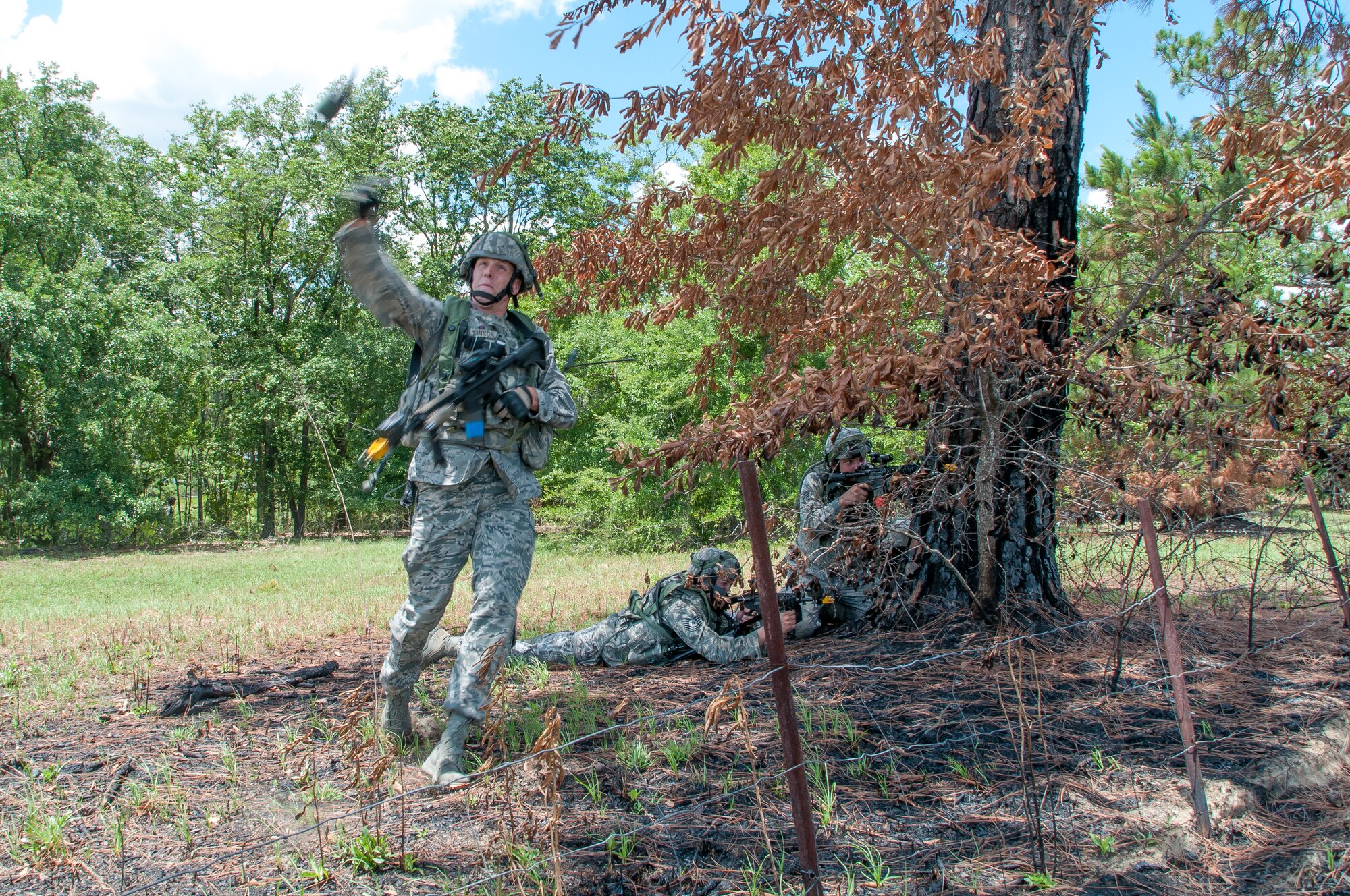 Staff Sgt. Jeff Stinson, 165th Airlift Wing Security Forces, throws a smoke grenade during Operation Spartan Fury, June 1, 2013 at Fort Stewart in Hinesville, Ga. Stinson and 165th defenders advanced under cover of smoke to retake a captured building during a combat scenario. (U.S. Air National Guard photo by Staff Sgt. Noel Velez/released)