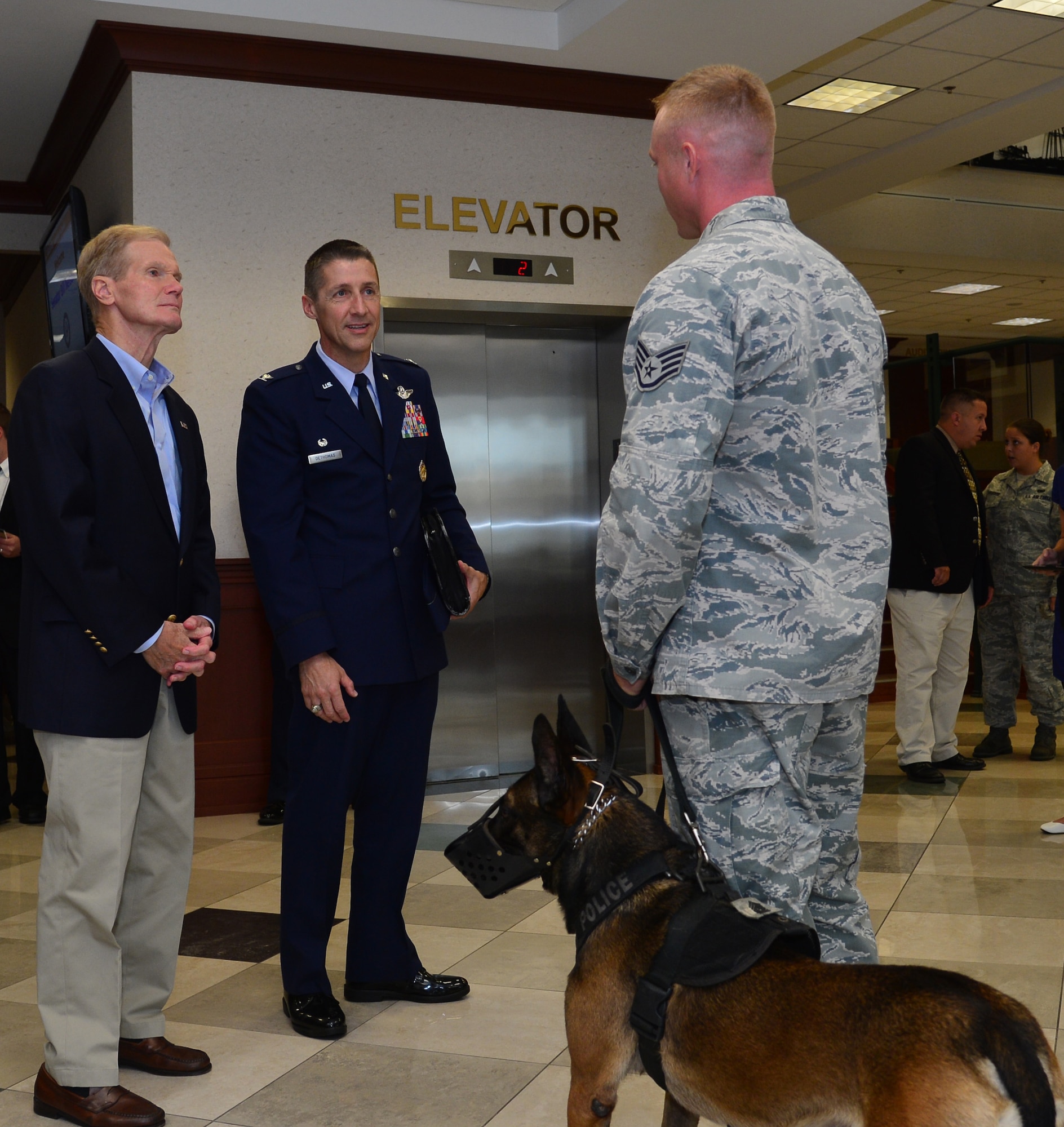 Bill Nelson, U.S. Senator for the state of Florida, and Col. Scott DeThomas, 6th Air Mobility Wing commander, speak with a 6th Security Forces Squadron military working dog handler about MacDill Air Force Base, Fla.’s security July 12, 2013. Nelson visited MacDill to check on the state of security after recent security breaches, and concluded that the installation is secure. (U.S. Air Force photo by Senior Airman Adam Grant/Released/cropped for point of interest)