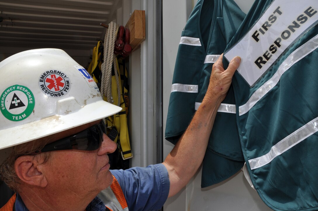 At the Olmsted Locks and Dam construction project, batch plant superintendent Rich Hamilton's hard hat carries both the original first responders' logo (left) and the current emblem. The stickers indicate authorization to be at an incident site - all others must stay clear. 