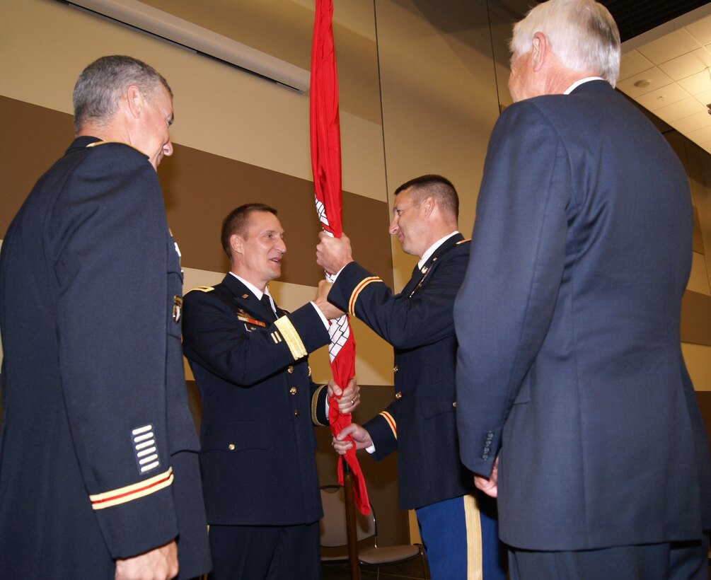 Col. Richard A. Pratt (right-center) accepts the Army Corps of Engineers flag, and with it command of the Corps’ Tulsa District, from Brig. Gen. Thomas Kula, the Corps’ Southwestern Division Commander, as his predecessor Col. Michael J. Teague, Tulsa District’s Commander (left) looks on during the district change of command ceremony. The event was held July 12 at the Armed Forces Reserve Center in Tulsa, Okla.