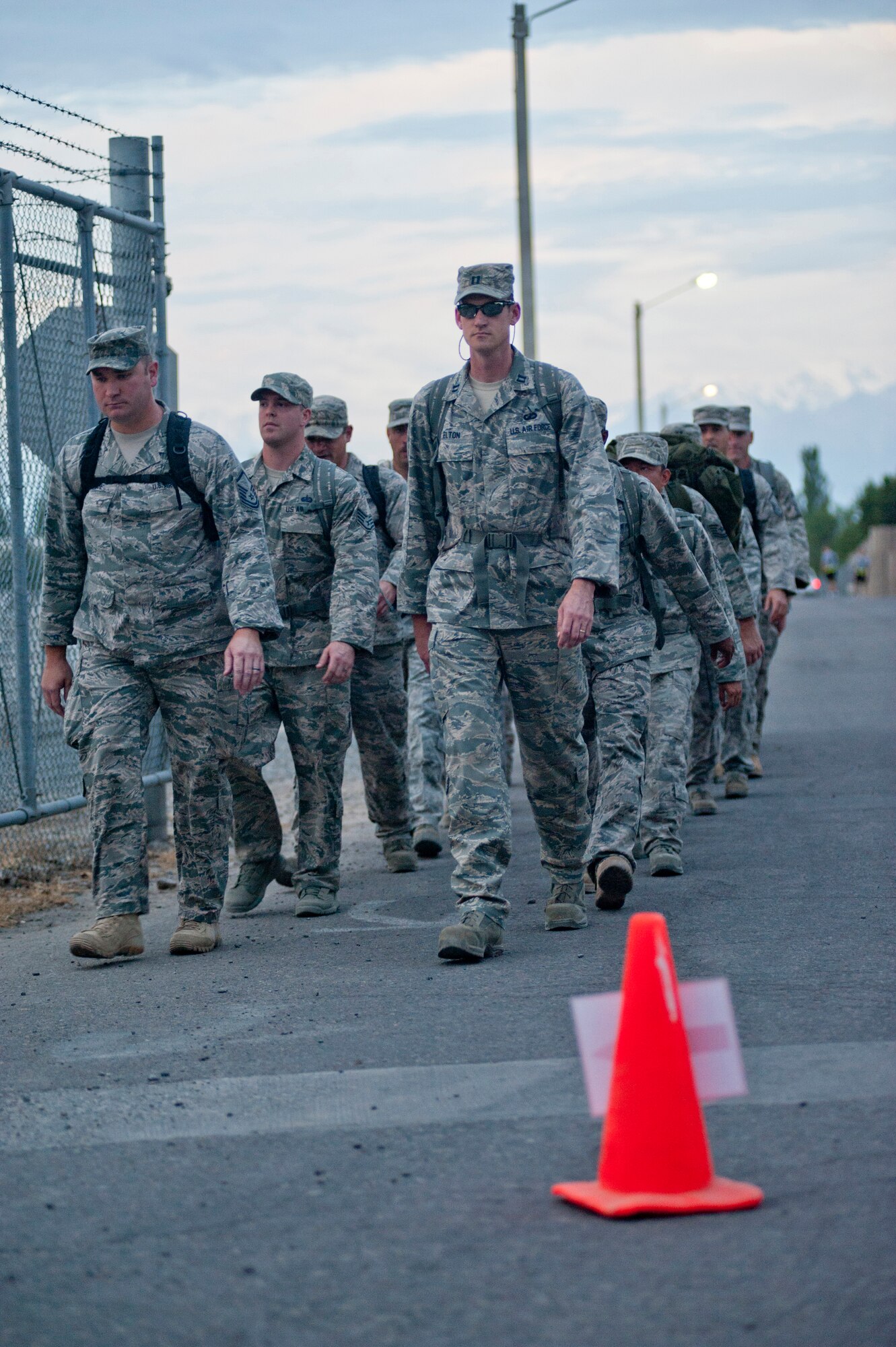 The Theater Security Cooperation detail, composed of every member of TSC carrying packs, marches in formation during the Transit Center at Manas' the Shell 77 Memorial 5K July 13, 2013, honoring three fallen aircrew members of TCM. TSC chose to honor the fallen warriors with a formation, starting and ending the 5K together, with no one left behind. (U.S. Air Force photo/Staff Sgt. Robert Barnett)