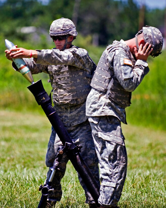 Army Spc. Robert Davis, left, prepares to fire an 81mm mortar system on Camp Atterbury, Ind., July 12, 2013. Davis is assigned to the Indiana National Guard's Headquarters Company, 1st Battalion, 293rd Infantry Regiment.