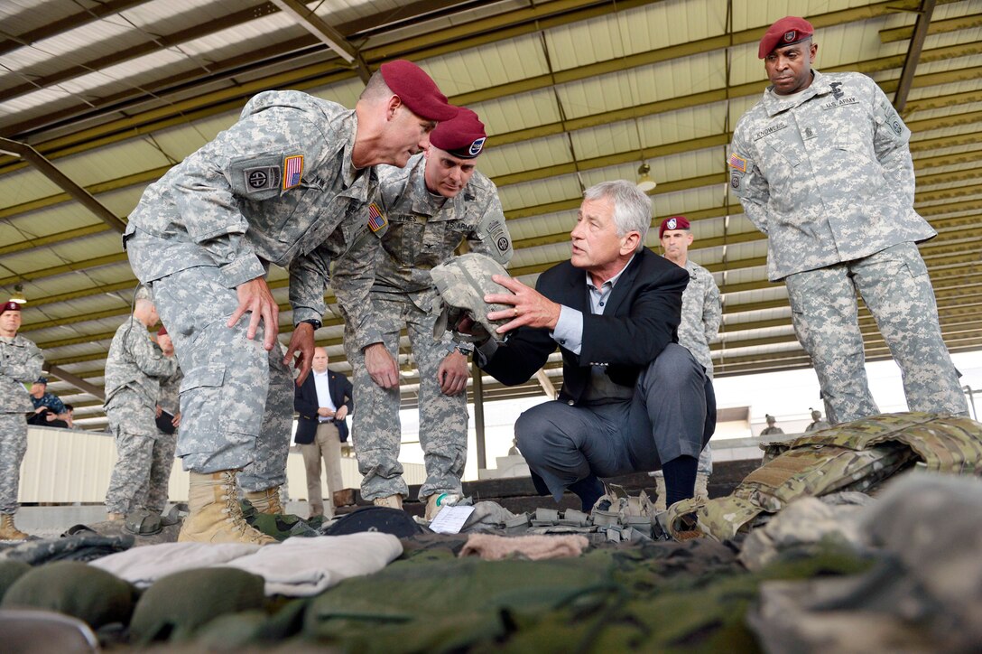 From left to right, Army Brig. Gen. Charlie Flynn, commanding general of the 82nd Airborne Division's operations; Army Col. Patrick Hynes, commander of the 82nd Airborne Division's 2nd Brigade Combat Team; Defense Secretary Chuck Hagel; Maj. Gen. John W. Nicholson Jr., commanding general of the 82nd Airborne Division; and Army Command Sgt. Maj. LaMarquis Knowles, the senior enlisted advisor for the 82nd Airborne Division, look over modern day soldier equipment as Hagel tours a Global Response Force unit on Fort Bragg, N.C., July 15, 2013. 
