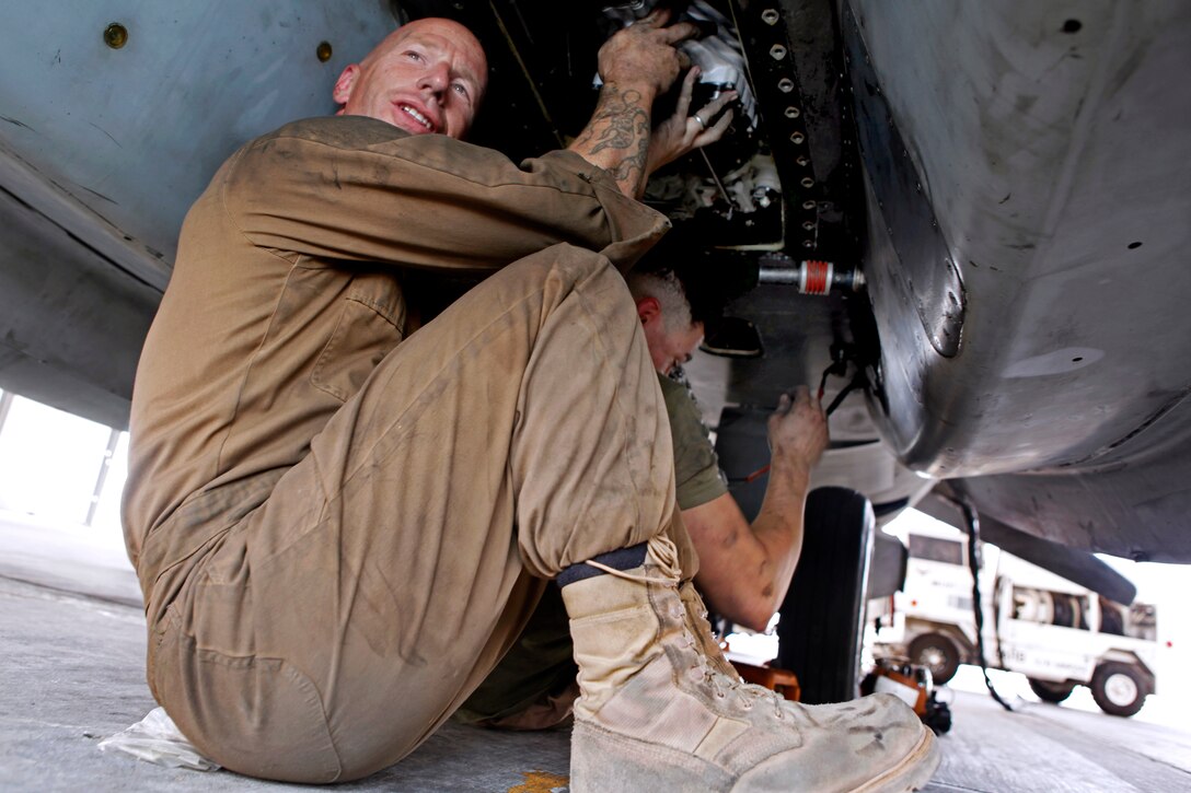 U.S. Marine Sgt. Maj. David A. Wilson, left, and U.S. Marine Cpl. Ubaldo F. Ozaeta install a single air motor servo unit on Camp Bastion, Helmand province, Afghanistan, July 15, 2013. Wilson and Ozaeta, powerline mechanics, are assigned to Marine Attack Squadron 311. The unit allows AV-8B Harriers to take off vertically.