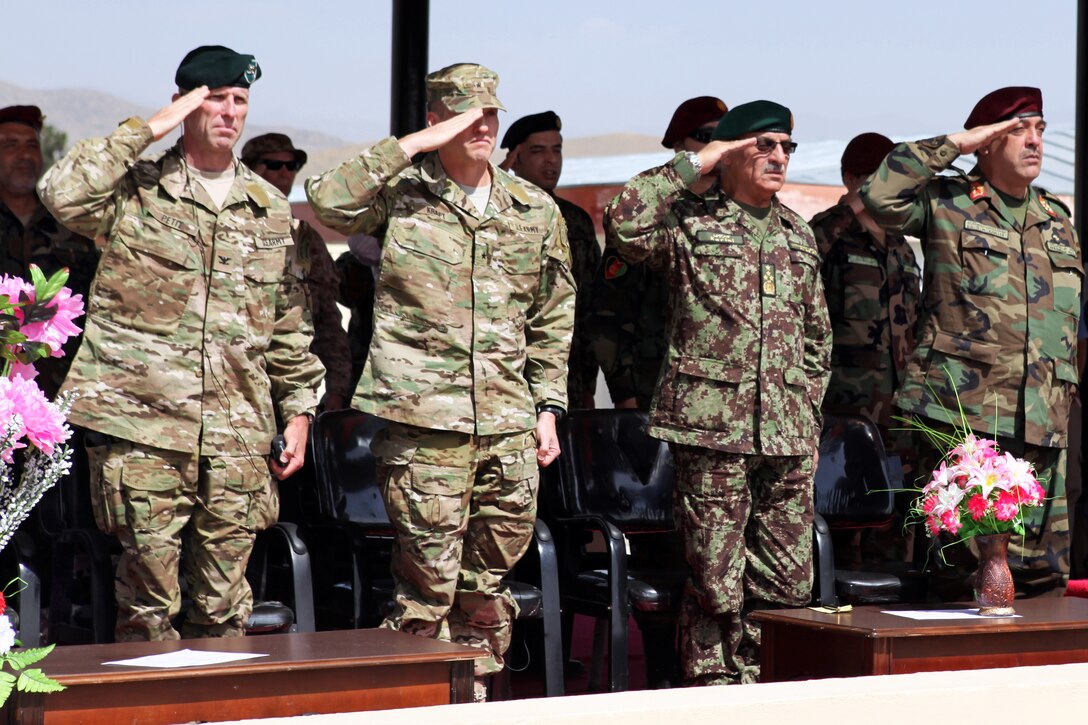 From left to right, U.S. Army Col. Brian Petit, U.S. Army Brig. Gen. James Kraft, Afghan army Chief of Staff Gen. Sher Mohammad Karimi and Afghan army Brig. Gen. Abdul Karim render honors at the start of the graduation ceremony for the Afghan army's special operations command on Camp Commando in Kabul, Afghanistan, July 11, 2013.