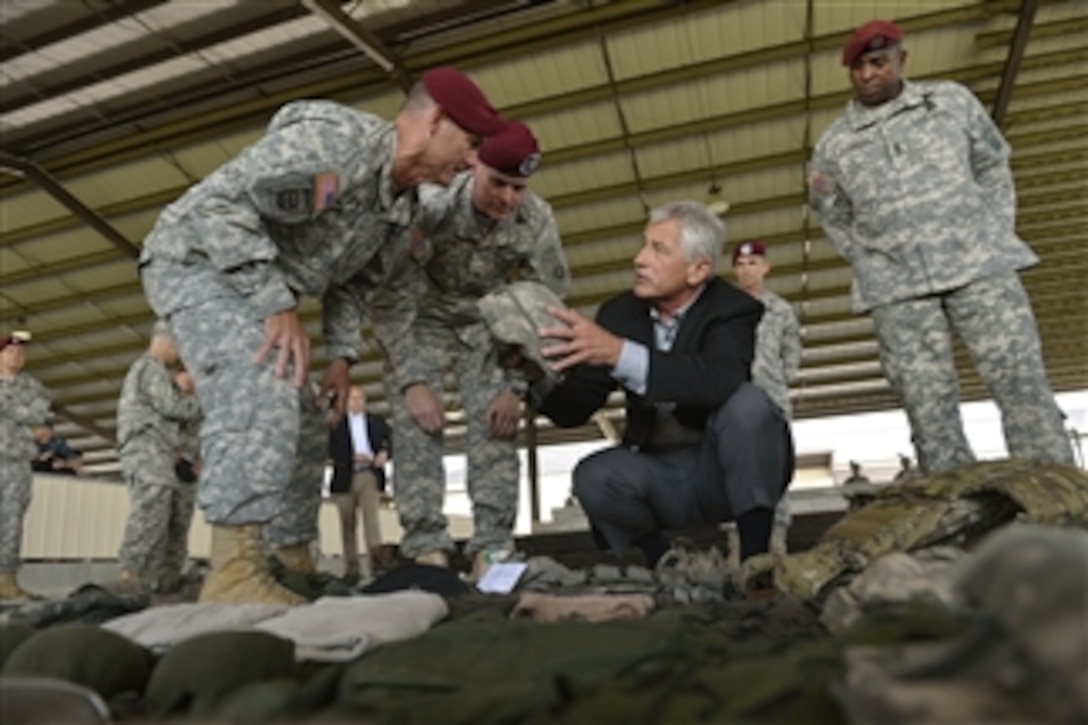 Secretary of Defense Chuck Hagel, center, holds up a soldier’s helmet as he discusses the equipment worn and carried by a modern day soldier as he tours the Global Response Force Airborne School at Fort Bragg, N.C., on July 15, 2013.  Hagel is visiting the Army post to talk with senior leaders, soldiers and civilian employees.  