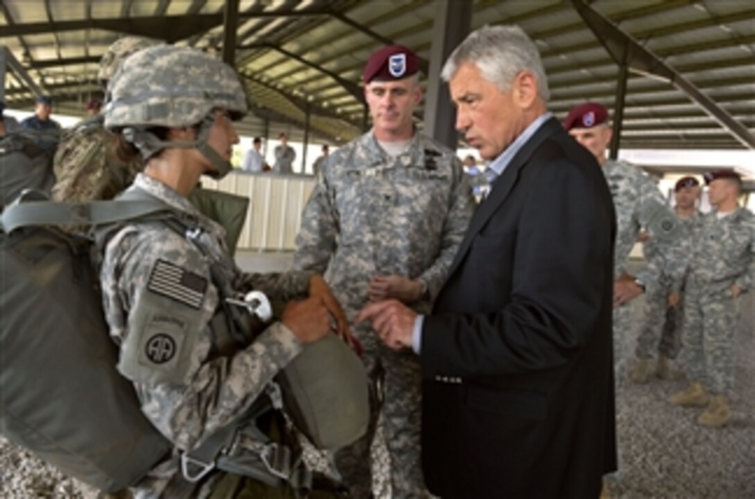 Secretary of Defense Chuck Hagel, right, talks with Army Sgt. Virginia Leal, left, about the parachutes she is wearing at the Global Response Force Airborne School at Fort Bragg, N.C., on July 15, 2013.  Hagel is visiting the Army post to talk with senior leaders, soldiers and civilian employees.  