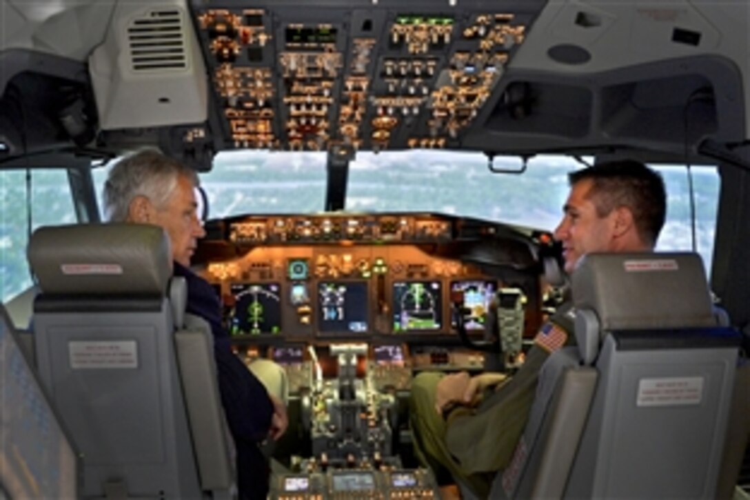 Defense Secretary Chuck Hagel, left, sits in the cockpit of a P-8 aircraft flight simulator as he visits the VP-30 training center on Naval Air Station Jacksonville, Fla., July 16, 2013. Hagel was allowed to fly the simulator and land in a simulated version off the runway of Joint Base Andrews, Md.