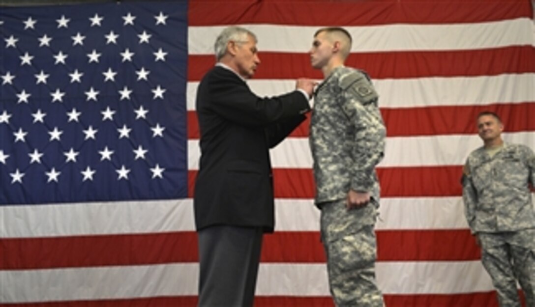 Secretary of Defense Chuck Hagel, left, awards the Purple Heart to Spc. Trevor Hoover during a troop event at Fort Bragg, N.C., on July 15, 2013.  Hagel is visiting the Army post to talk with senior leaders, soldiers and civilian employees.  