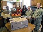 Spc. Tameka Gray, Capt. Bradley Roach, Staff Sgt. Ashley Laws and Chief Warrant Officer (2) Michael Decker help two Holy Angels helpers unpack the surplus food that they delivered to the Holy Angel Homeless Shelter. Soldiers of the 1344th Transportation Company based in East St. Louis will deliver food to different shelters throughout their community after each drill.