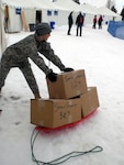 Army Guard Staff Sgt. Laura Schmitt, assigned to the Joint Force Headquarters in Idaho, loads snowshoe equipment at the Sun Valley Nordic Center during the Special Olympics Invitational Games held last February. The event helped all organizations involved plan for this year's big event.