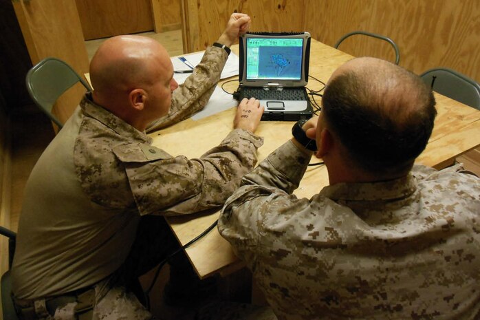 Sgt. Joshua S. Tufts (right), squad leader in 3rd Battalion, 9th Marines, and Maj. Brad Sams, project officer for Tactical Service Oriented Architecture, review the laptop display of the Patrol Planning and Assessment Tool. The mapping application brings GPS-based technology to patrol leaders’ fingertips. 