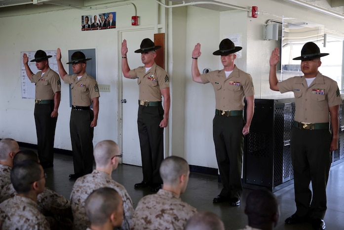 The drill instructors of Company G, 2nd Recruit Training Battalion, recite the Drill Instructors Creed during Pick Up aboard Marine Corps Recruit Depot San Diego July 12. The oath is administered by the series commander during the recruits first introduction to their drill instructors.