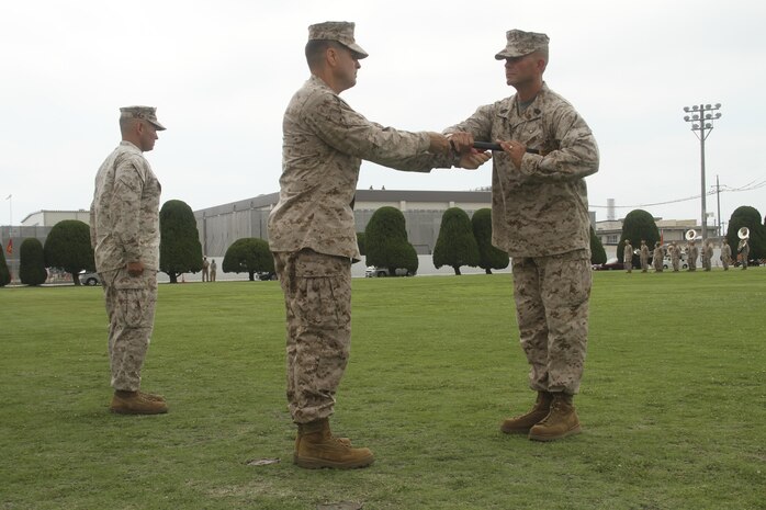 Col. Robert V. Boucher, Marine Corps Air Station commanding officer, passes the Sword of Office to Sgt. Maj. Keith Massi during a relief and appoint ceremony July 12, 2013. Boucher assumed the billet of station commanding officer in the ceremony that took place before the relief and appointment.