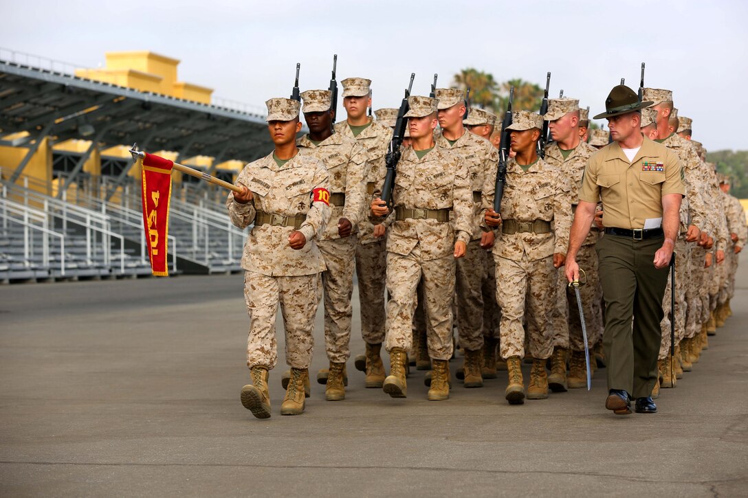 Sgt. Nicholas Milner, senior drill instructor, Company B, 1st Recruit Training Battalion, leads the platoon in executing eyes-right during Final Drill aboard Marine Corps Recruit Depot San Diego June 15. Eyes right is a drill movement performed as the platoon marches past the flag, it represents a salute.