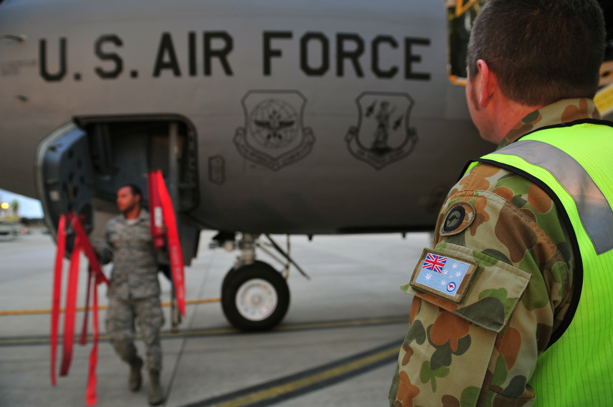 Royal Australian Air Force Sergeant Christopher Sharp, 1st Airfield Operations Support Squadron, looks on as U.S. Air Force Airmen start to deplane a KC-135 Stratotanker, RAAF Base Amberley, Australia, July 15, 2013. Two KC-135s arrived to support Talisman Saber 2013, an exercise that provides realistic, relevant training necessary to maintain regional security, peace and stability. (U.S. Air Force photo by Staff Sgt. Rachelle Coleman/Released)