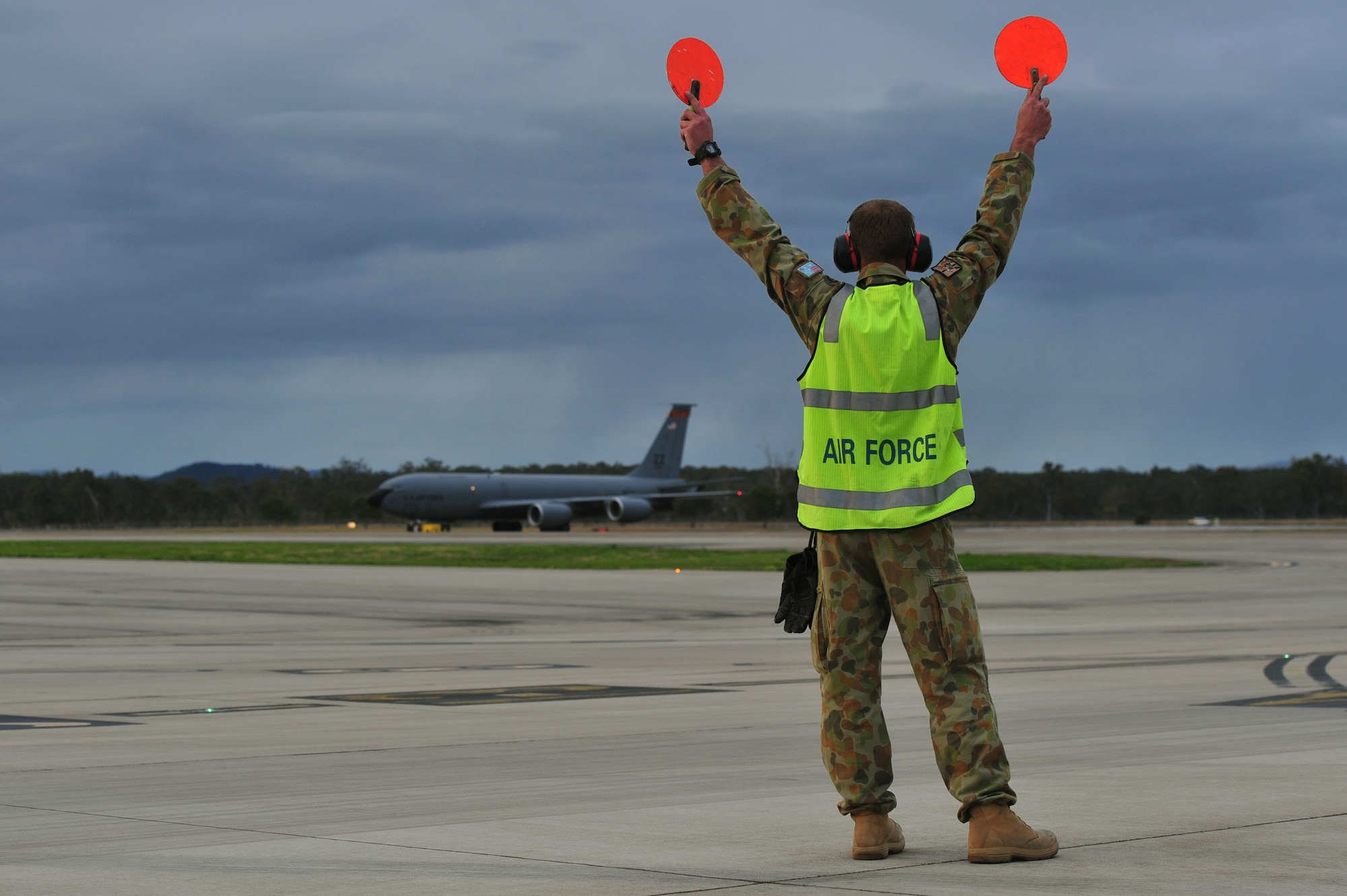 Royal Australian Air Force Leading Aircraftman Damien Deering, assigned to the No. 1 Airfield Operations Support Squadron, marshalls a U.S. Air Force KC-135 Stratotanker from Kadena Air Base, Japan, at Royal Australian Air Force Base Amberley, Australia, July 15, 2013. Two KC-135s arrived to provide aerial refueling during Talisman Saber 2013, a biennial training activity aimed at improving Australian Defence Force and U.S. combat readiness and interoperability as a combined joint task force. (U.S. Air Force photo by Staff Sgt. Rachelle Coleman/Released)