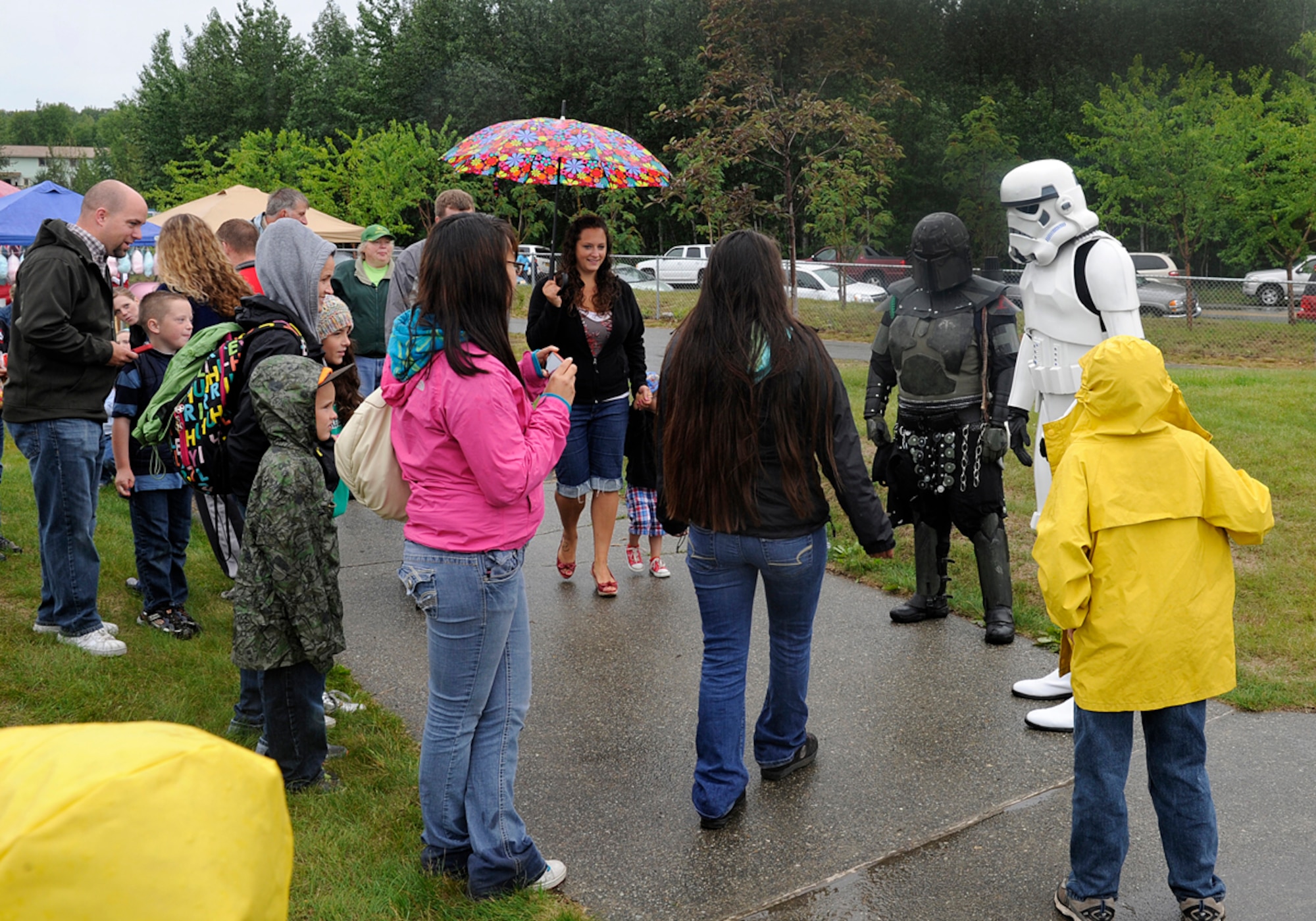 Air Force Staff Sgt. Patrick Walsh, 673d Communications Squadron cyber transport supervisor, poses for a picture with fans in Wasilla, Alaska, July 4, 2013. Walsh is a member of the 501st, which is an all volunteer organization that makes movie accurate costumes and wears them to promote interest in Star Wars, encourage use of the costumes made, and to contribute to the local community. (U.S. Air Force photo/Staff Sgt. Zachary Wolf)