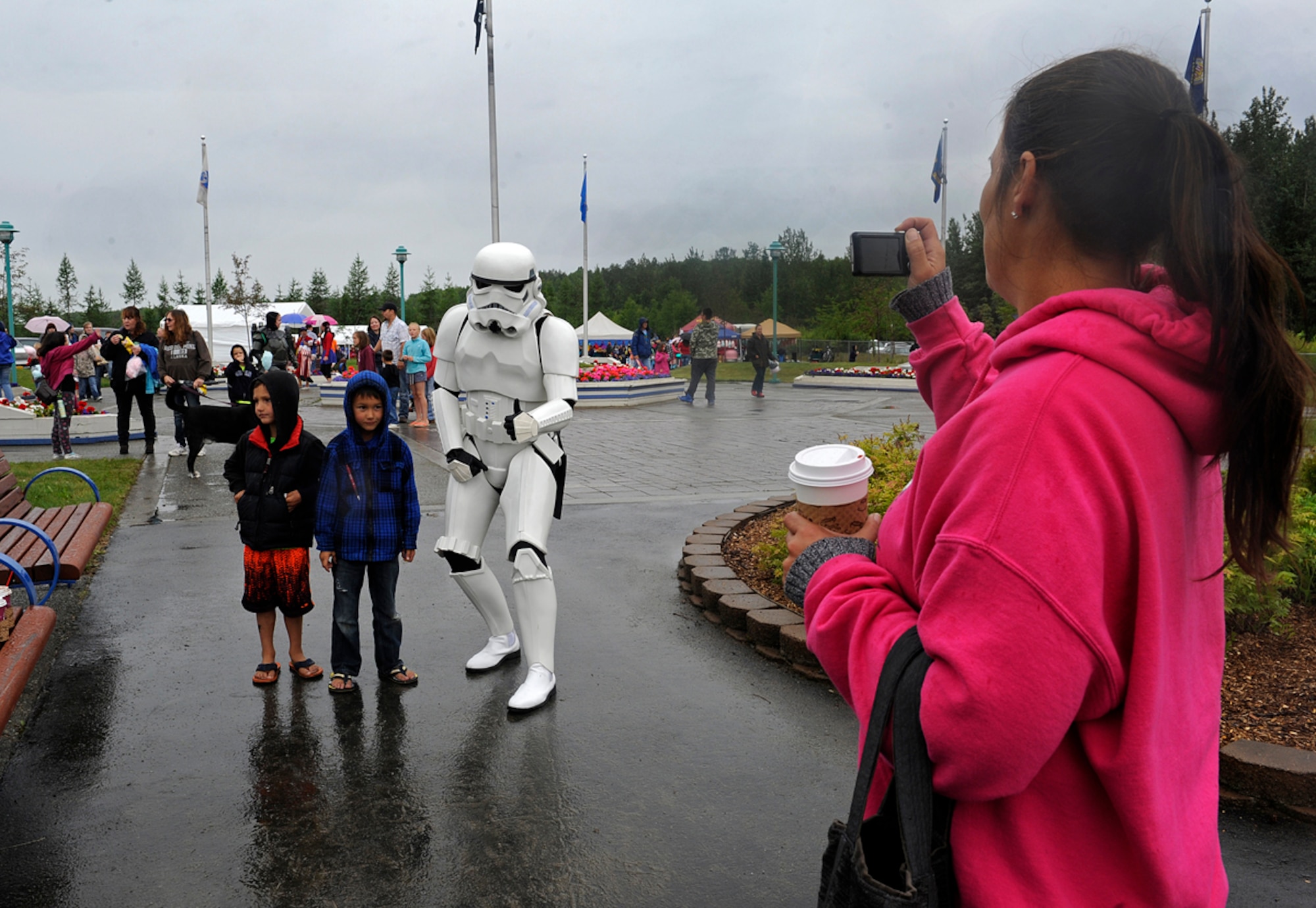 Air Force Staff Sgt. Patrick Walsh, 673d Communications Squadron cyber transport supervisor, poses for a picture with fans in Wasilla, Alaska, July 4, 2013. Walsh is a member of the 501st, which is an all volunteer organization that makes movie accurate costumes and wears them to promote interest in Star Wars, encourage use of the costumes made, and to contribute to the local community. (U.S. Air Force photo/Staff Sgt. Zachary Wolf)