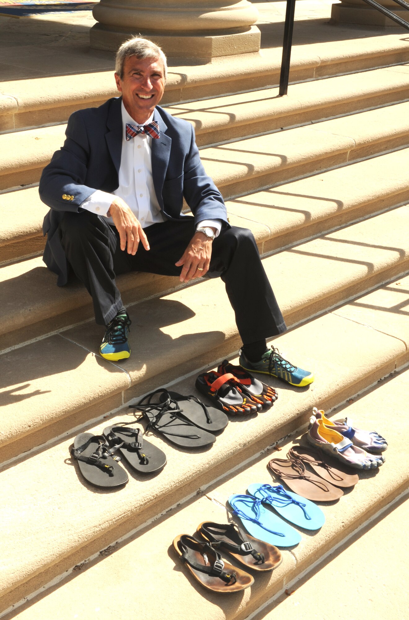Frank Jones, 375th Air Mobility Wing communications support coordinator, displays his different running shoes and sandals.  The retired Air Force colonel has sandals that allow him to run in the rain or snow, by providing extra grip.  He also has sandals that allow him to run on trails.  In addition to wearing sandals, he also runs barefoot. (U.S. Air Force photo/Staff Sgt. Maria Bowman)