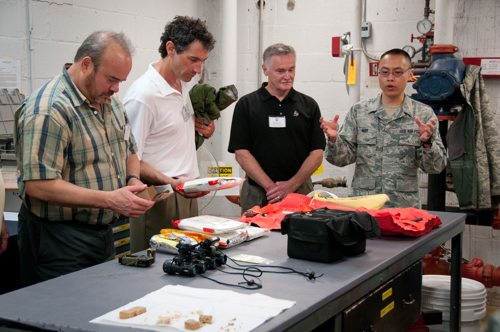 Staff Sgt. Laishun Mak, 934th Operation Support Squadron, explains usage of flight gear to (right to left) William Droste, Dr. Kirk Shibley, and Lawrence Jacobs, Honorary Commanders, during a tour of the 934th Airlift Wing.  The HC program helps strengthen community partnerships with the 934 AW, Minneapolis-St. Paul Air Reserve Station, Minn.  (U.S. Air Force photo/MSgt. Scott Farley)