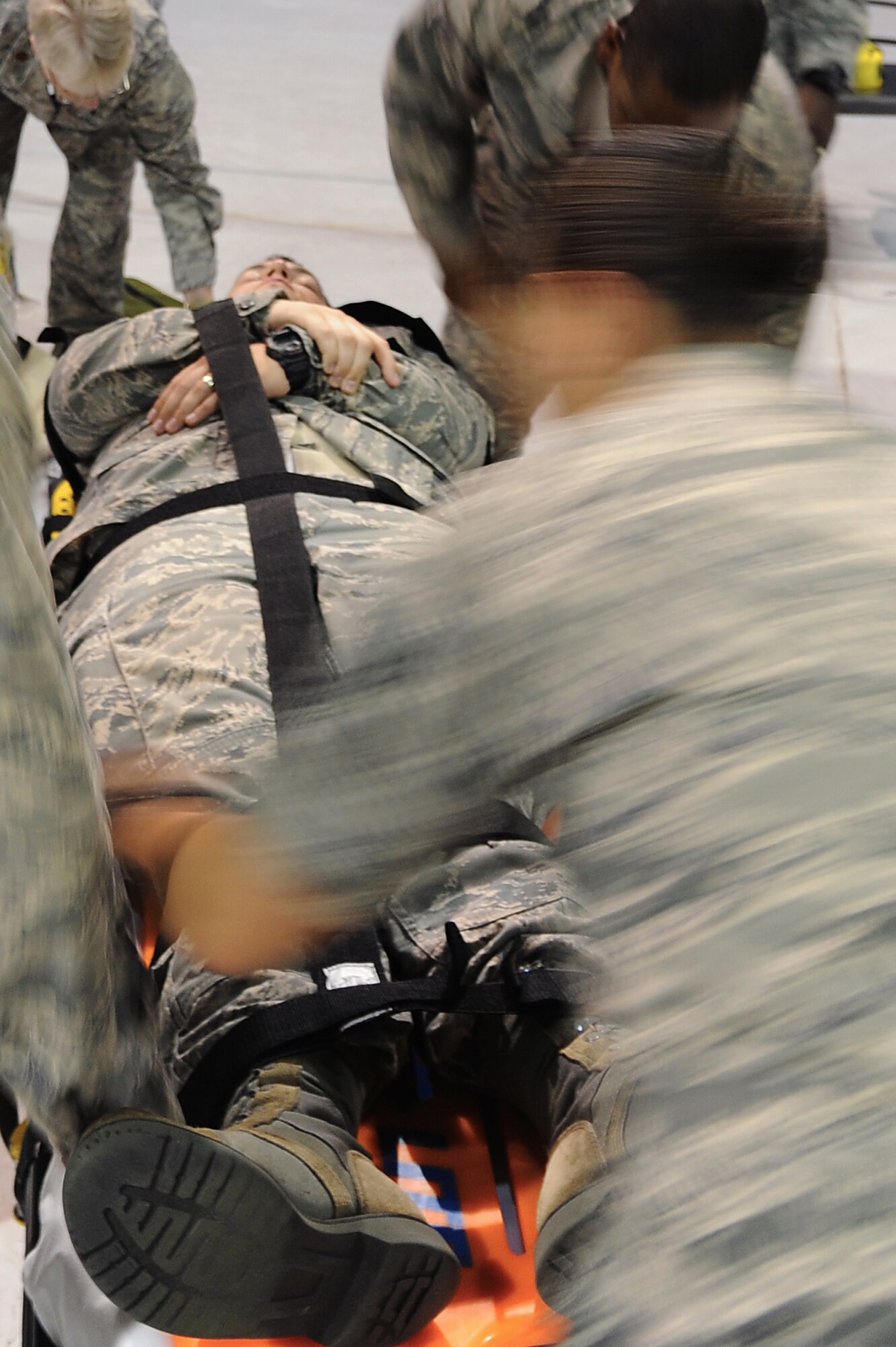 U.S. Air Force Airmen secure Senior Airman Zachary Reischman, 633rd Force Support Squadron knowledge operations journeyman, to a stretcher after he simulated a heart attack during a Major Accident Response Exercise at Langley Air Force Base, Va., July 16, 2013. Exercises like the MARE test the responders’ ability in high-stress situations in the event of a real-world emergency. (U.S. Air Force photo by Airman 1st Class Victoria H. Taylor/Released)