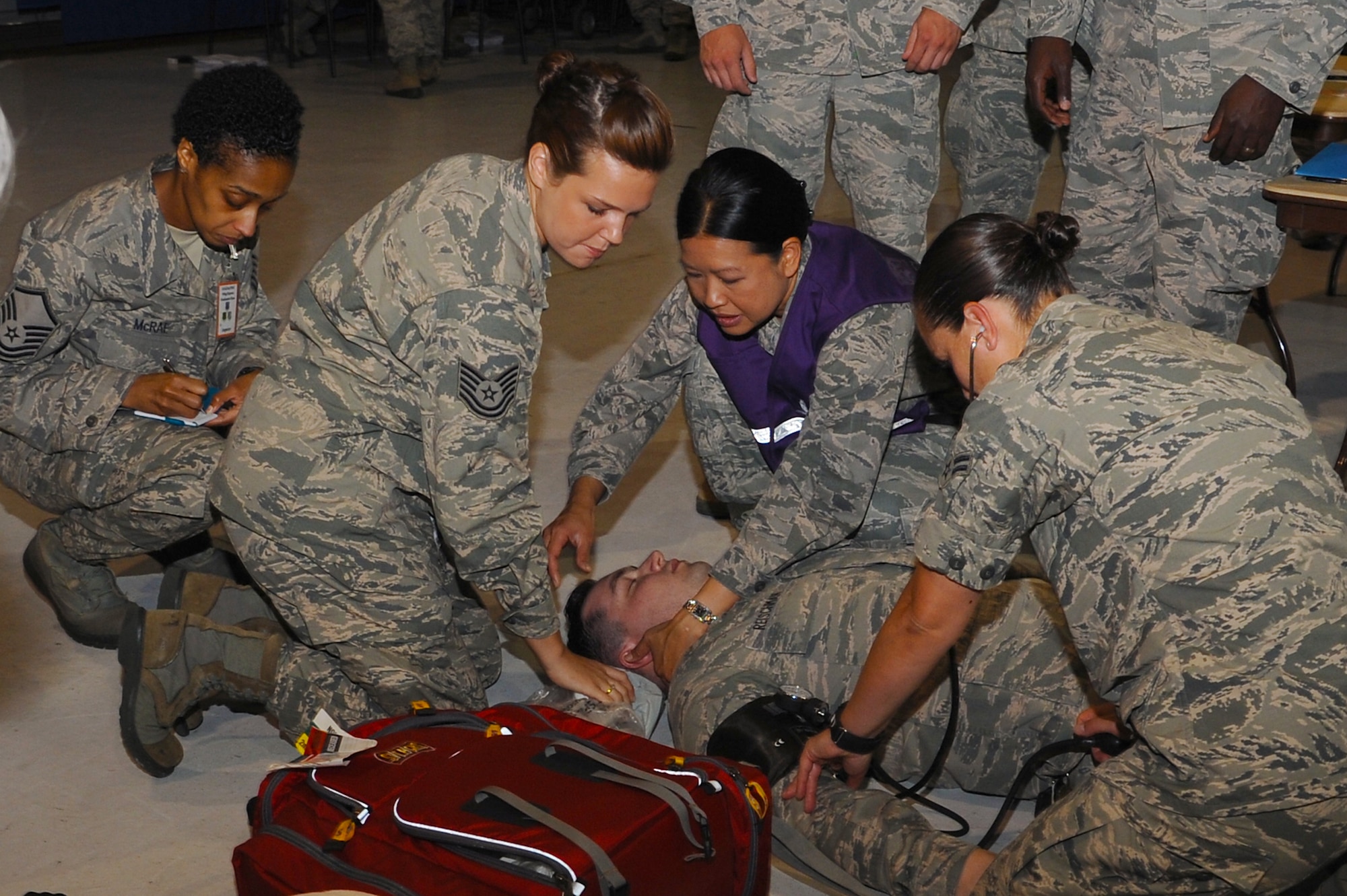 U.S. Air Force Airmen simulate providing care to Senior Airman Zachary Reischman, 633rd Force Support Squadron knowledge operations journeyman, after he simulates a heart attack during a major accident exercise at Langley Air Force Base, Va., July 16, 2013. The goal of the Major Accident Response Exercise was to distribute 400 medications per hour to the people on base, demonstrating emergency capabilities. (U.S. Air Force photo by Airman 1st Class Victoria H. Taylor/Released)