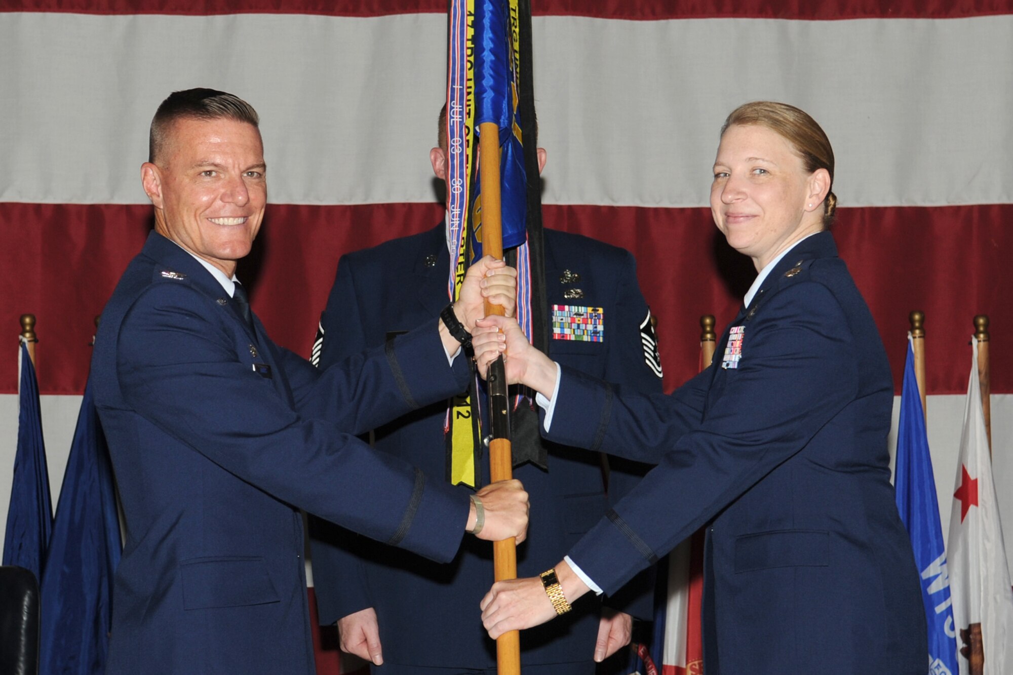 GOODFELLOW AIR FORCE BASE, Texas -- Col. Brendan Harris, 17th Training Group Commander, passes the 315th Training Squadron guidon to the incoming commander, Lt. Col. Caeli Hull, during the Change of Command ceremony, July 17. The change of command ceremony is steeped in tradition and allows units to witness the formal command transfer from one officer to another.  (U.S. Air Force photo by Staff Sgt. Laura R. McFarlane)
