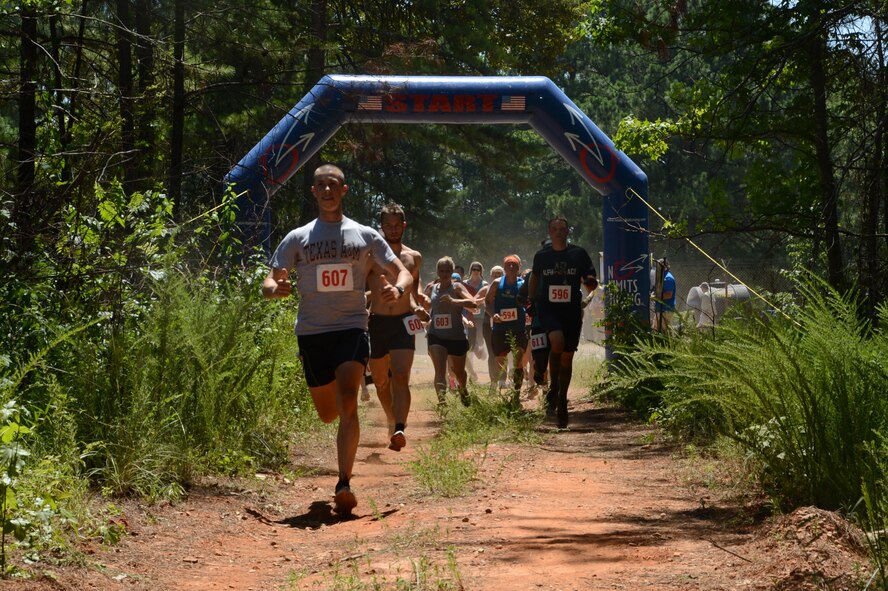 Runners take off from the start of the championship wave during the alphARace at the East Reservation on Barksdale Air Force Base, July 13, 2013. More than 600 members of Team Barksdale and local community took on the 4.2 miles of woods, mud and obstacles. All runners received a swag bag with personalized dog tags, a t-shirt, drink voucher and race bib and also enjoyed camaraderie between Team Barksdale and the local communities over music and food.(U.S. Air Force photo/Staff Sgt. Amber Corcoran)