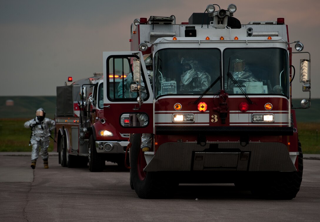 Airmen of the 28th Civil Engineer Squadron Fire Department gear up for a mobile aircraft arresting system test during the Phase II portion of an operational readiness exercise at Ellsworth Air Force Base, S.D., July 11, 2013. The MAS test ensures Fire Department personnel are able to reel the arresting system back in a timely manner for future aircraft to be able to use the system. (U.S. Air Force photo by Airman 1st Class Alystria Maurer/Released)