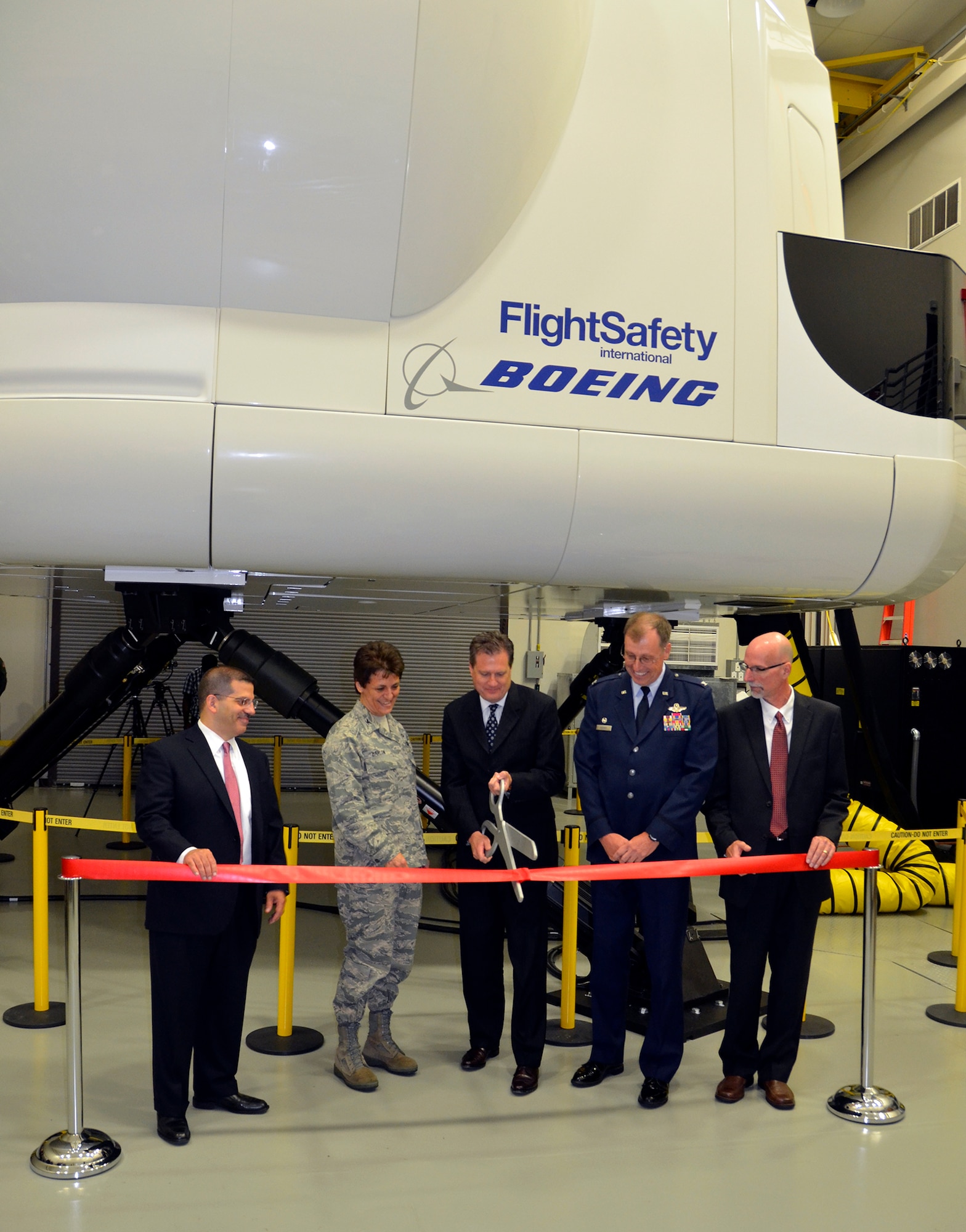 WRIGHT-PATTERSON AIR FORCE BASE, Ohio – Base and local community leaders participated in a ribbon cutting ceremony July 16 celebrating the official opening of a new C-17 Simulator Training Facility here. The facility includes a new and fully networked C-17 weapon system trainer, a training management system, computer-based training devices, a core integrated processor task trainer and portable flight-planning devices. It also has the ability to be networked with other U.S. Air Force WST devices around the world for cross-team mission training. Cutting the ribbon are (from left to right); Lenny Genna, L-3 Link Simulation and Training president, Col. Cassie Barlow,  88th Air Base Wing commander, Congressman Michael Turner, U.S. Representative for Ohio’s 10th District, Col. Stephen Goeman, 445th Airlift Wing commander, and Tracy Mead, Program Manager, C-17 Aircrew Training System, the Boeing Company. Having the C-17 simulator here will save the wing approximately $1 million a year because the 120 pilots and loadmasters assigned to the wing can do their annual and refresher training here instead of traveling to other bases. (U.S. Air Force photo/Master Sgt. Charlie Miller)