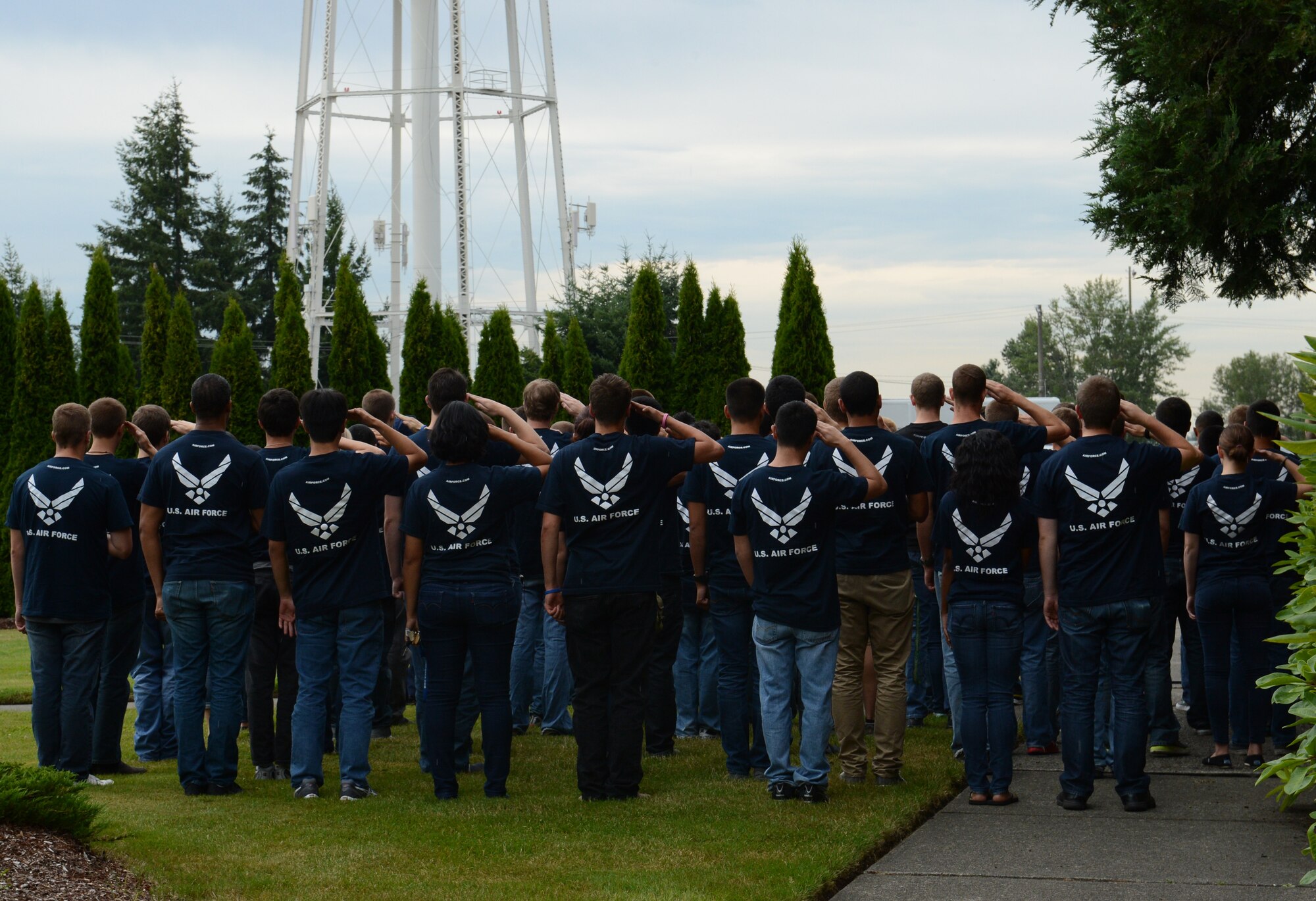Individuals who are part of the Air Force Delayed Entry Program salute alongside Lt. Gen. Darren McDew, 18th Air Force commander, during the playing of retreat and the National Anthem July 16, 2013 at Joint Base Lewis-McChord, Wash. When McDew heard the playing of retreat, he asked everyone to join him outside to pay respect to the flag. (U.S. Air Force photo/Staff Sgt. Frances Kriss)